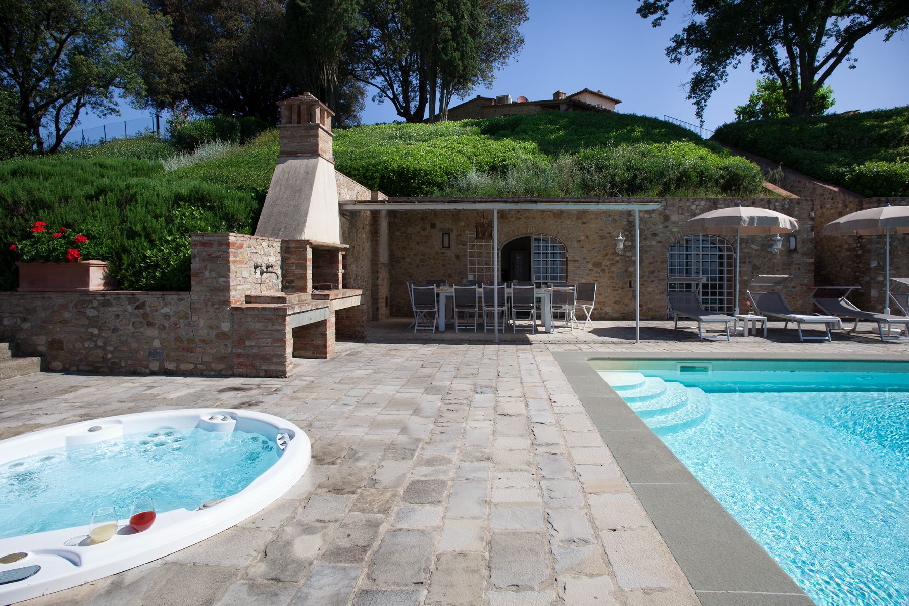 Outdoor pool area with view of the jacuzzi next to the pool at Villa di Tignano in Tuscany