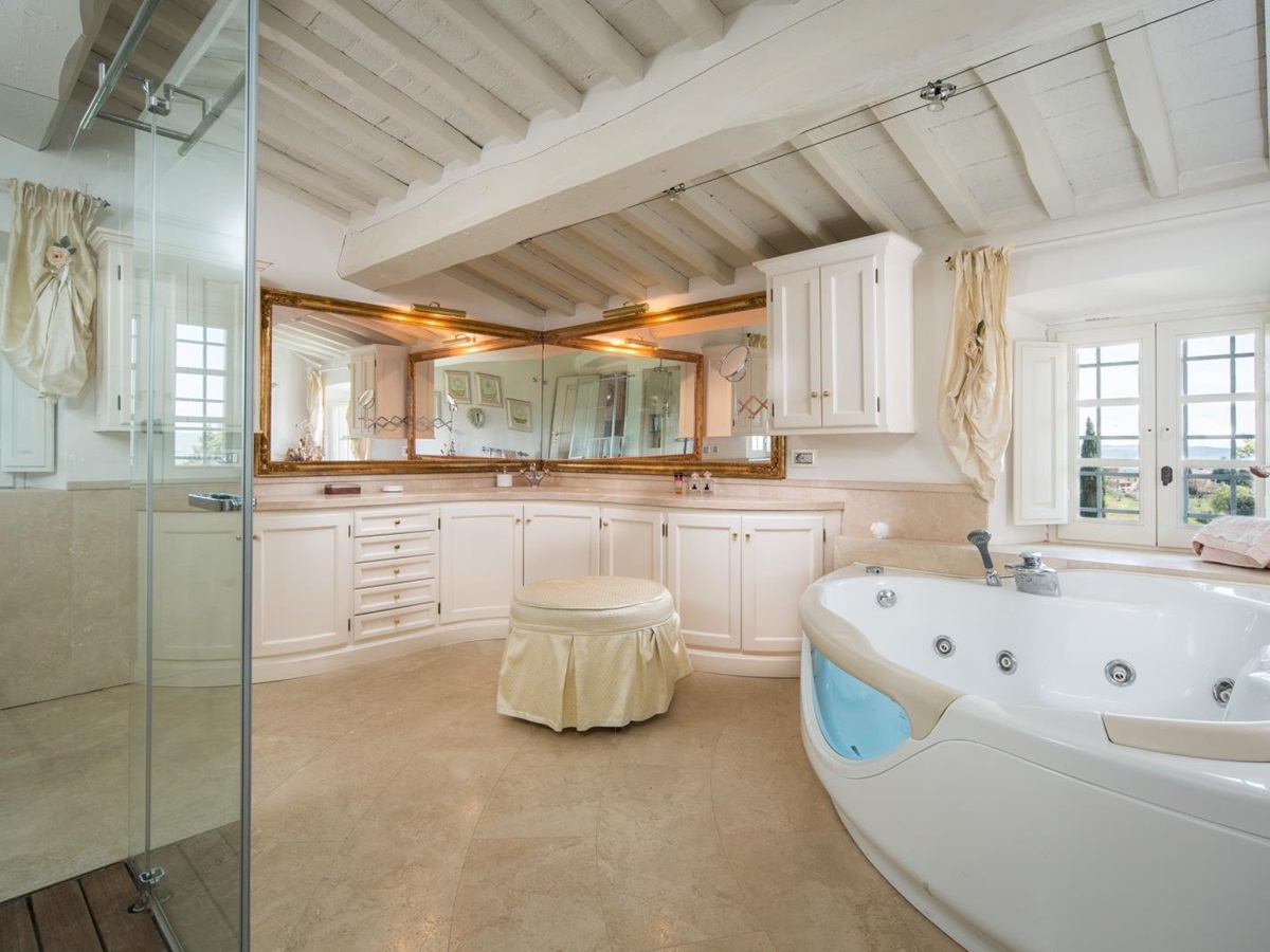 Large master bathroom with jacuzzi bath, shower and large sink unit with mirrors at Villa di Tignano in Tuscany, Italy