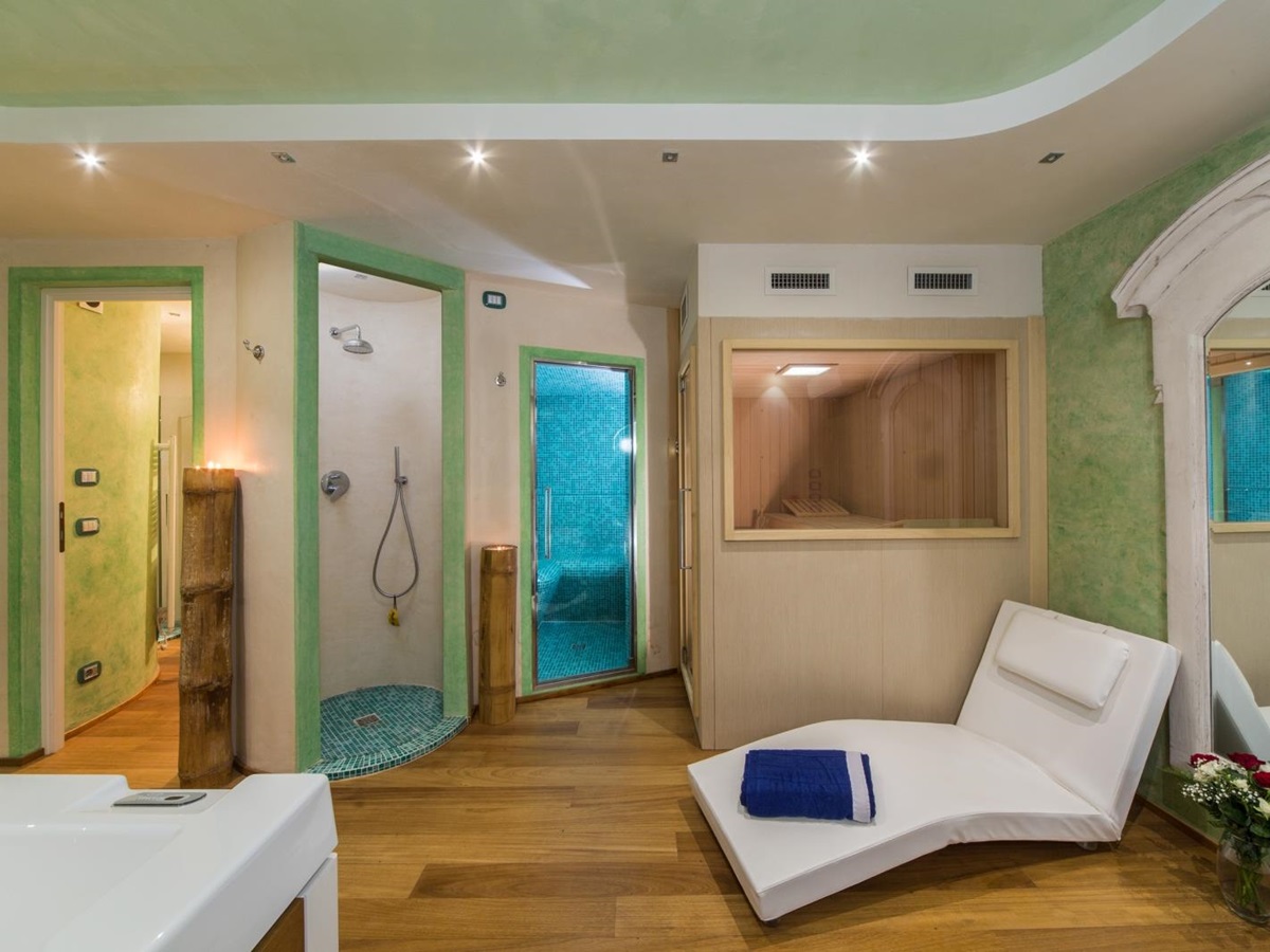 Spa room with jacuzzi, shower, lounge chair and sauna at Villa di Tignano in Tuscany, Italy