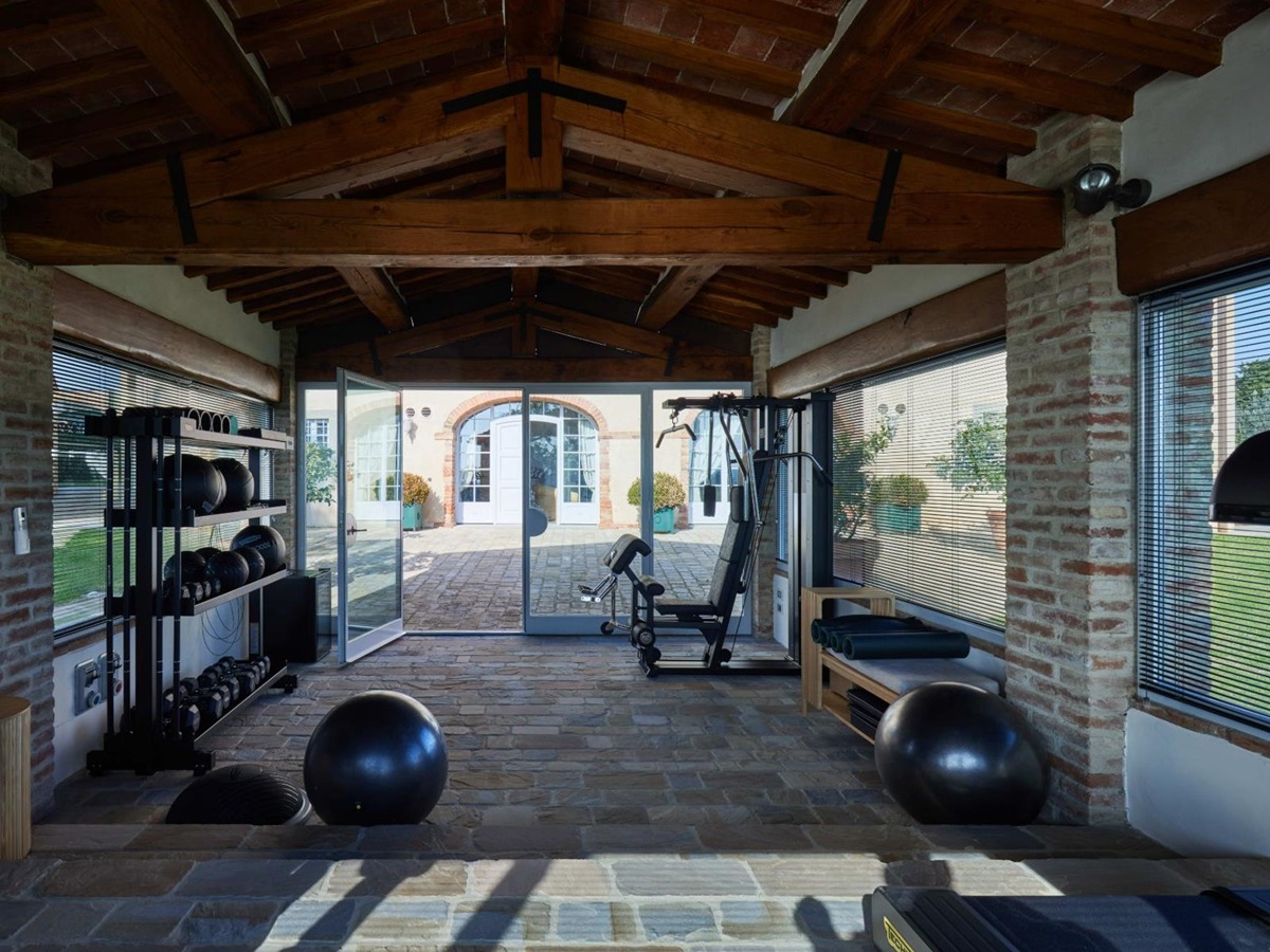 Gym in the palestro building with gym equipment and stone floors at Villa di Tignano in Tuscany