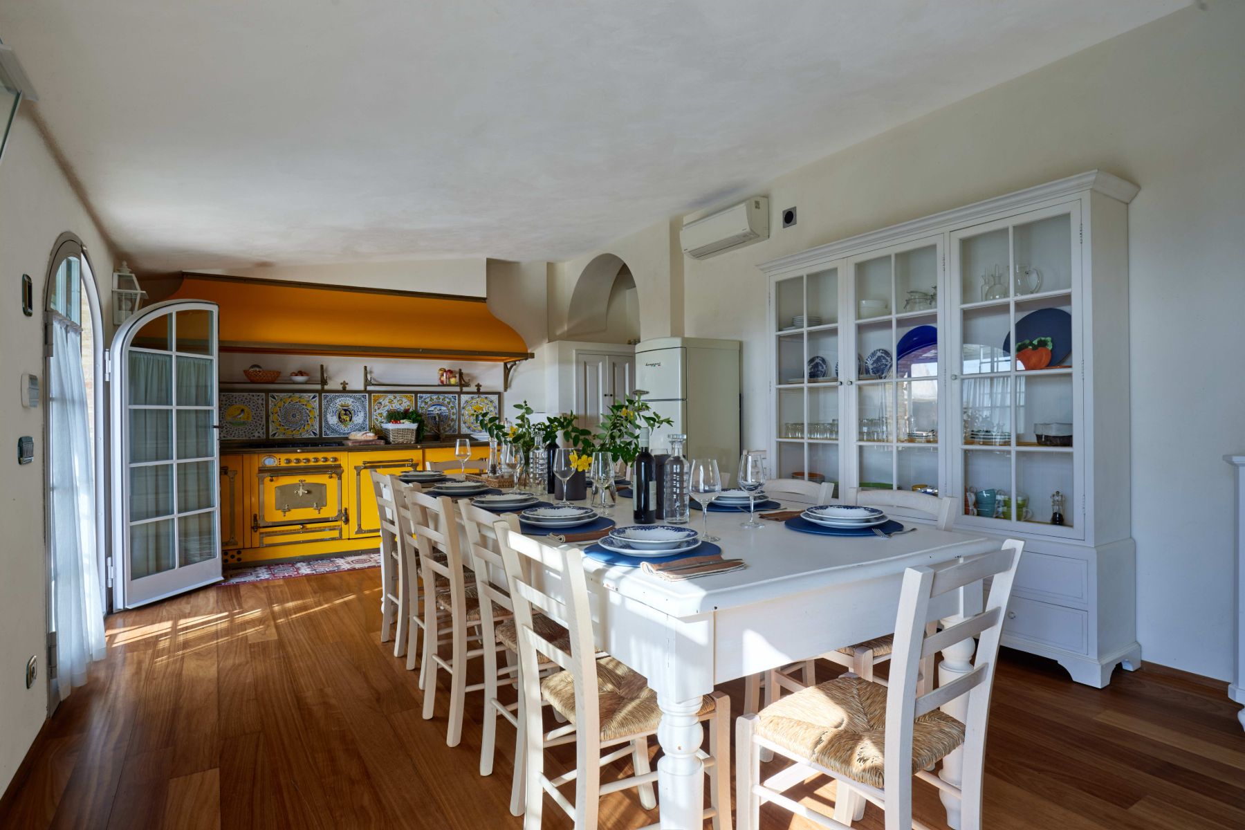 Kitchen with large white table and chairs in the middle at Villa di Tignano in Tuscany