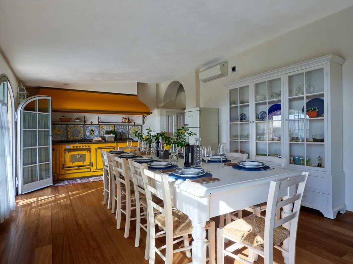 Kitchen with large white table and chairs in the middle at Villa di Tignano in Tuscany