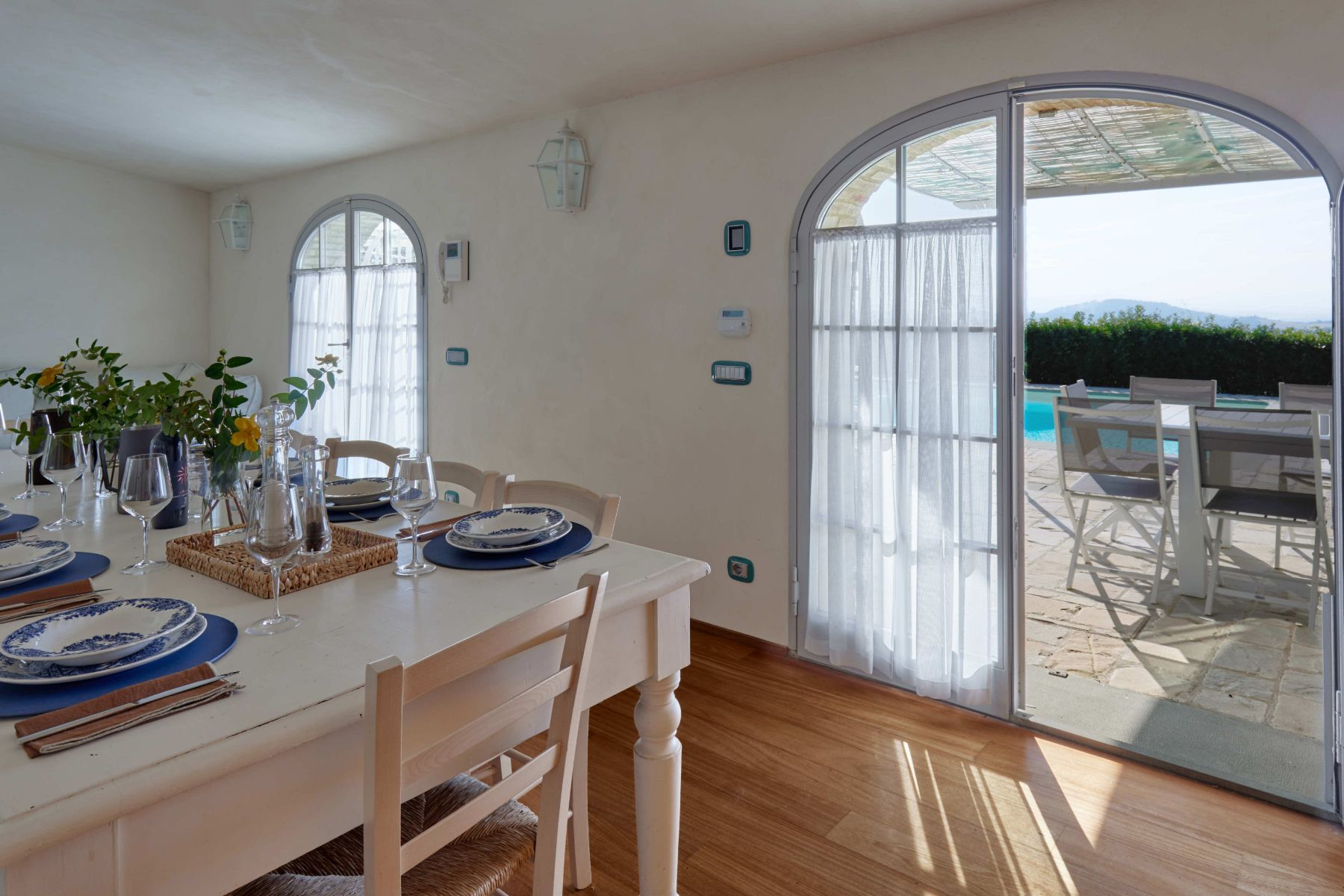 View of the outdoor pool area from inside the kitchen at Villa di Tignano in Tuscany