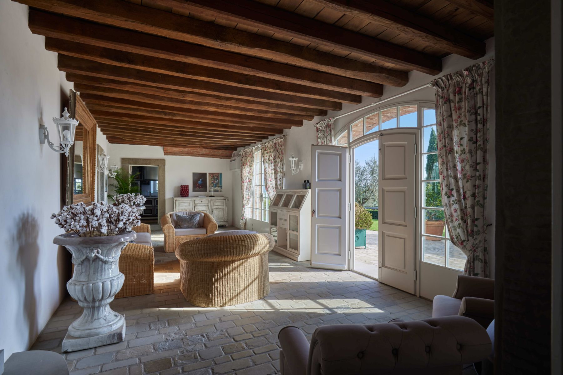 Living room with view of the outdoor area with large open doors at Villa di Tignano in Tuscany