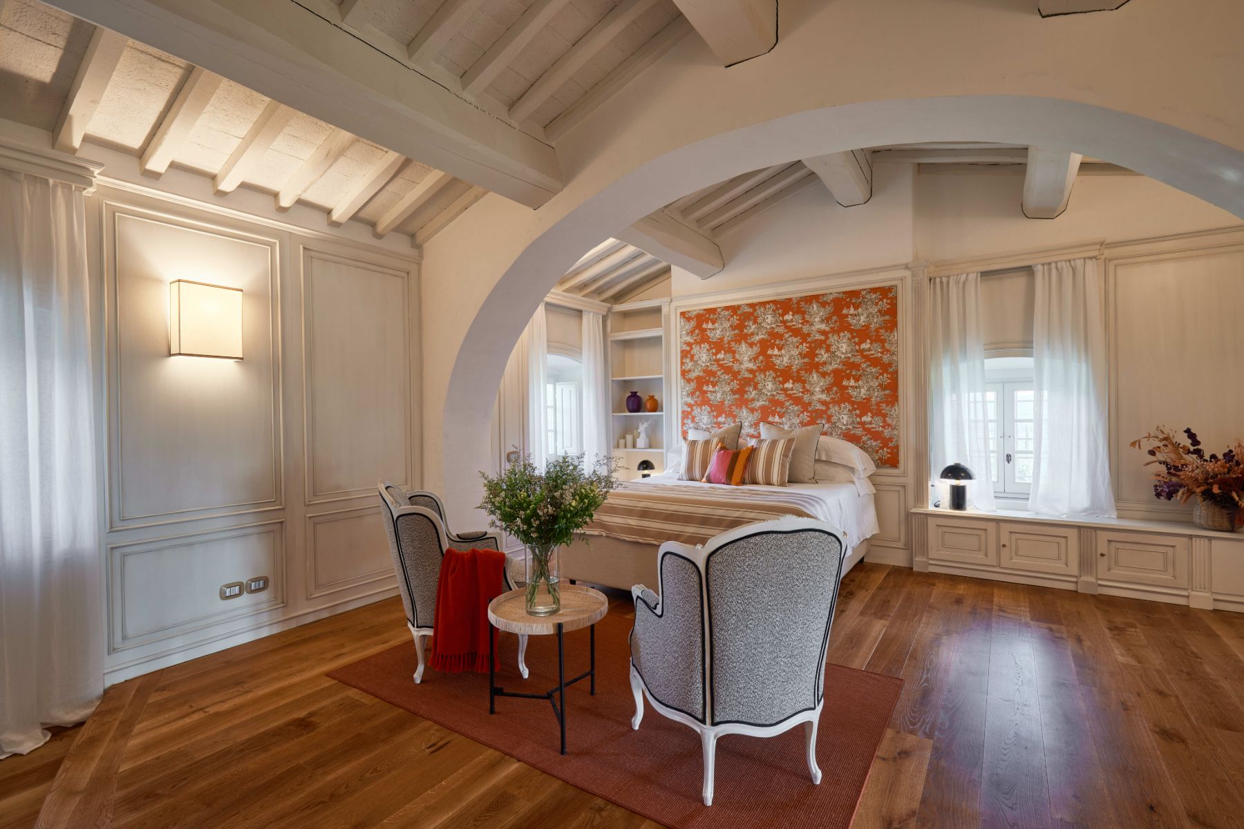 Master bedroom with a table and chairs and wooden floors at Villa di Tignano in Tuscany