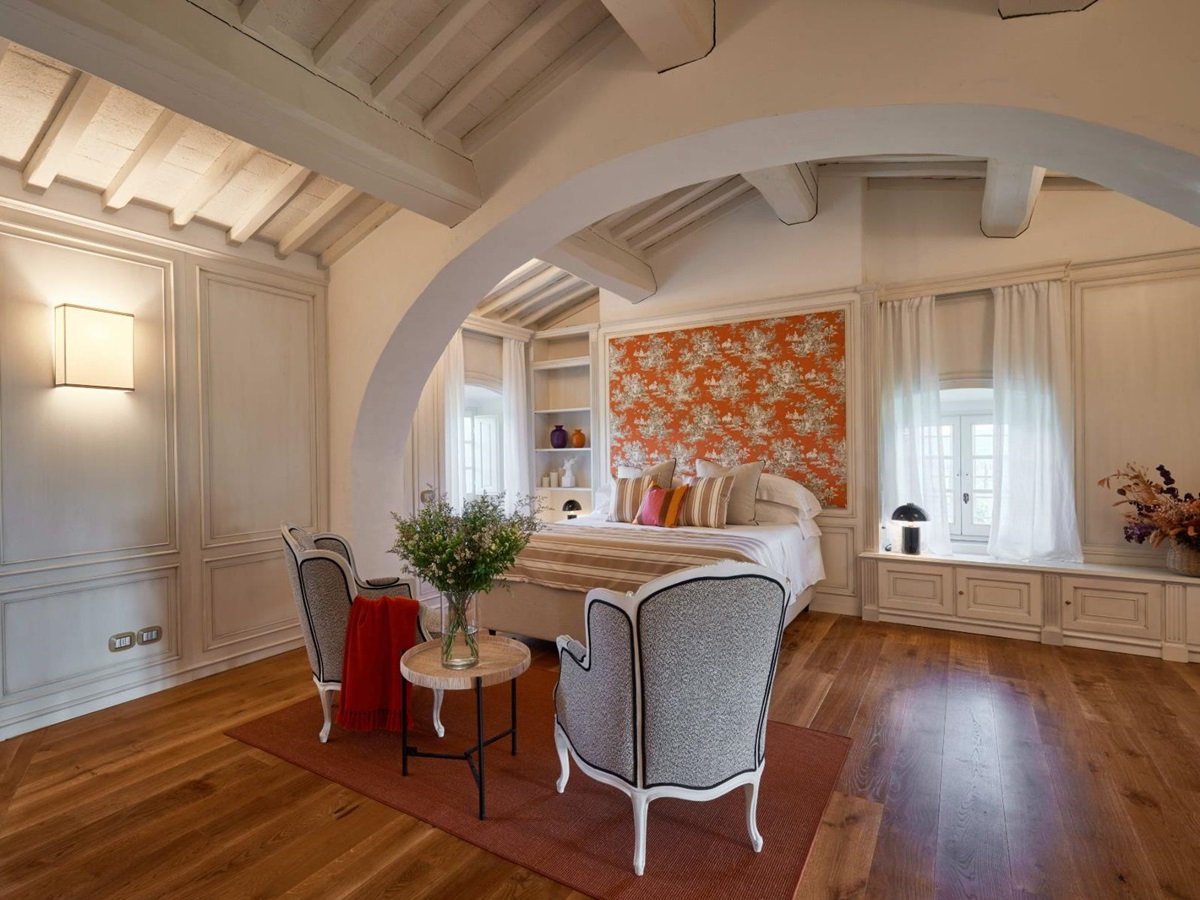 Master bedroom with a table and chairs and wooden floors at Villa di Tignano in Tuscany