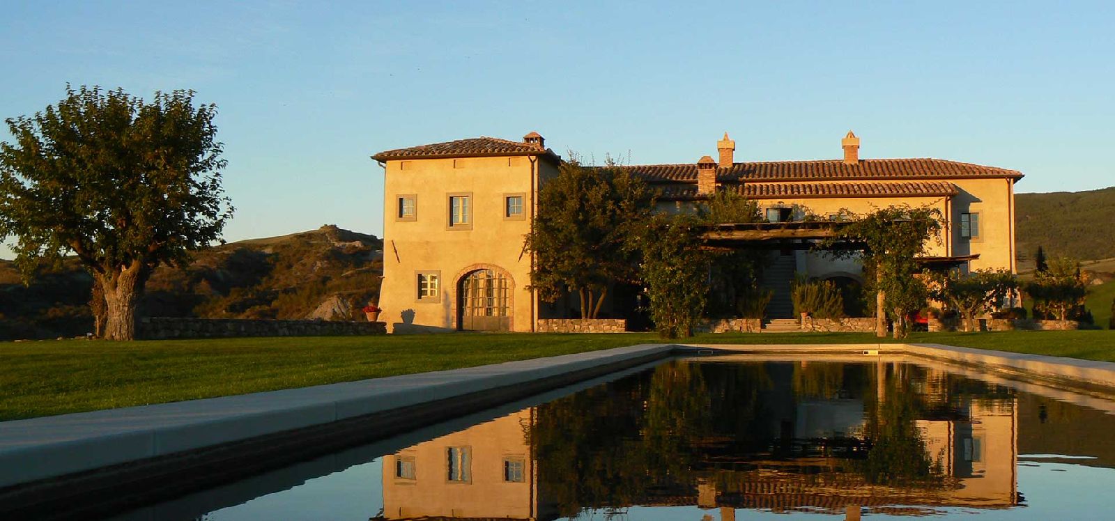 Villa d'Orcia in Tuscany reflected in swimming pool at sunset