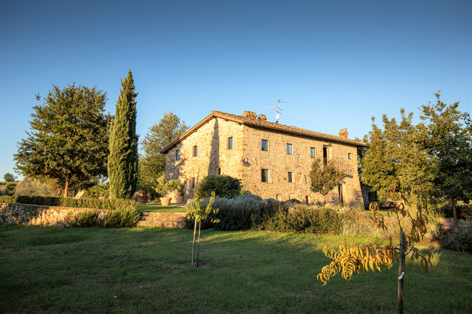 Exterior of villa and garden with trees and plants at Villa Giuliana in Tuscany, Italy