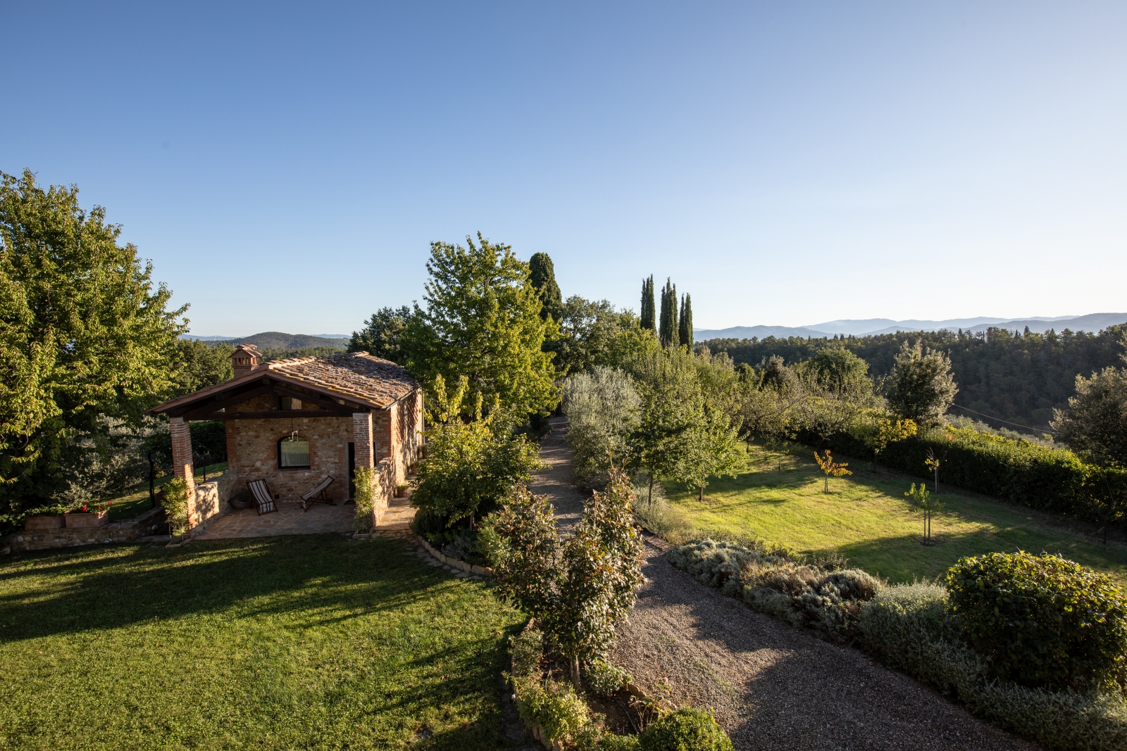 Annexe in garden with trees, plants and countryside view at Villa Giuliana in Tuscany, Italy