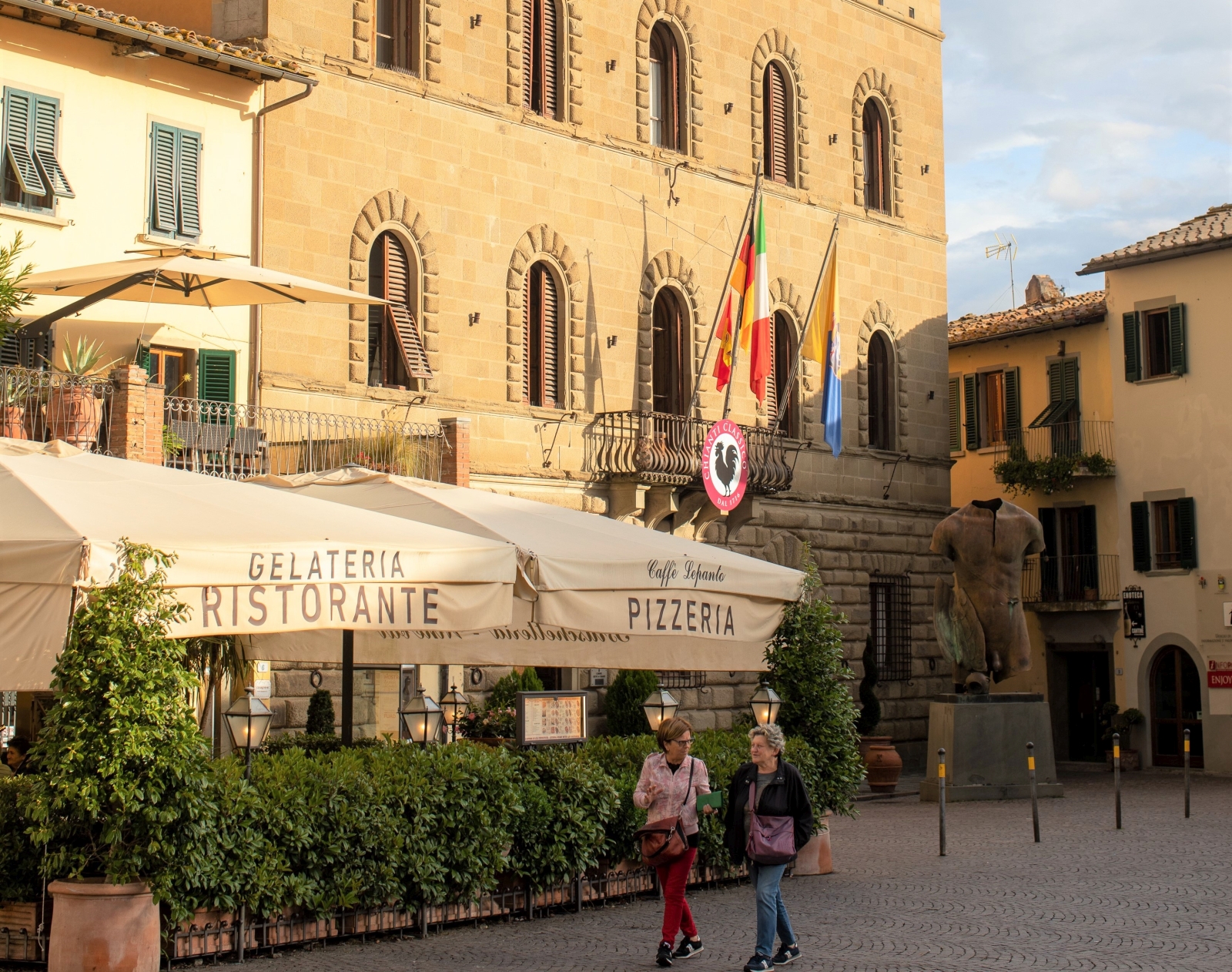 Lifestyle image with pizzeria, local friends and town hall in Greve in Chianti near to Villa Giuliana in Tuscany, Italy
