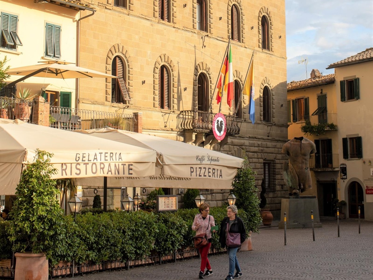 Lifestyle image with pizzeria, local friends and town hall in Greve in Chianti near to Villa Giuliana in Tuscany, Italy
