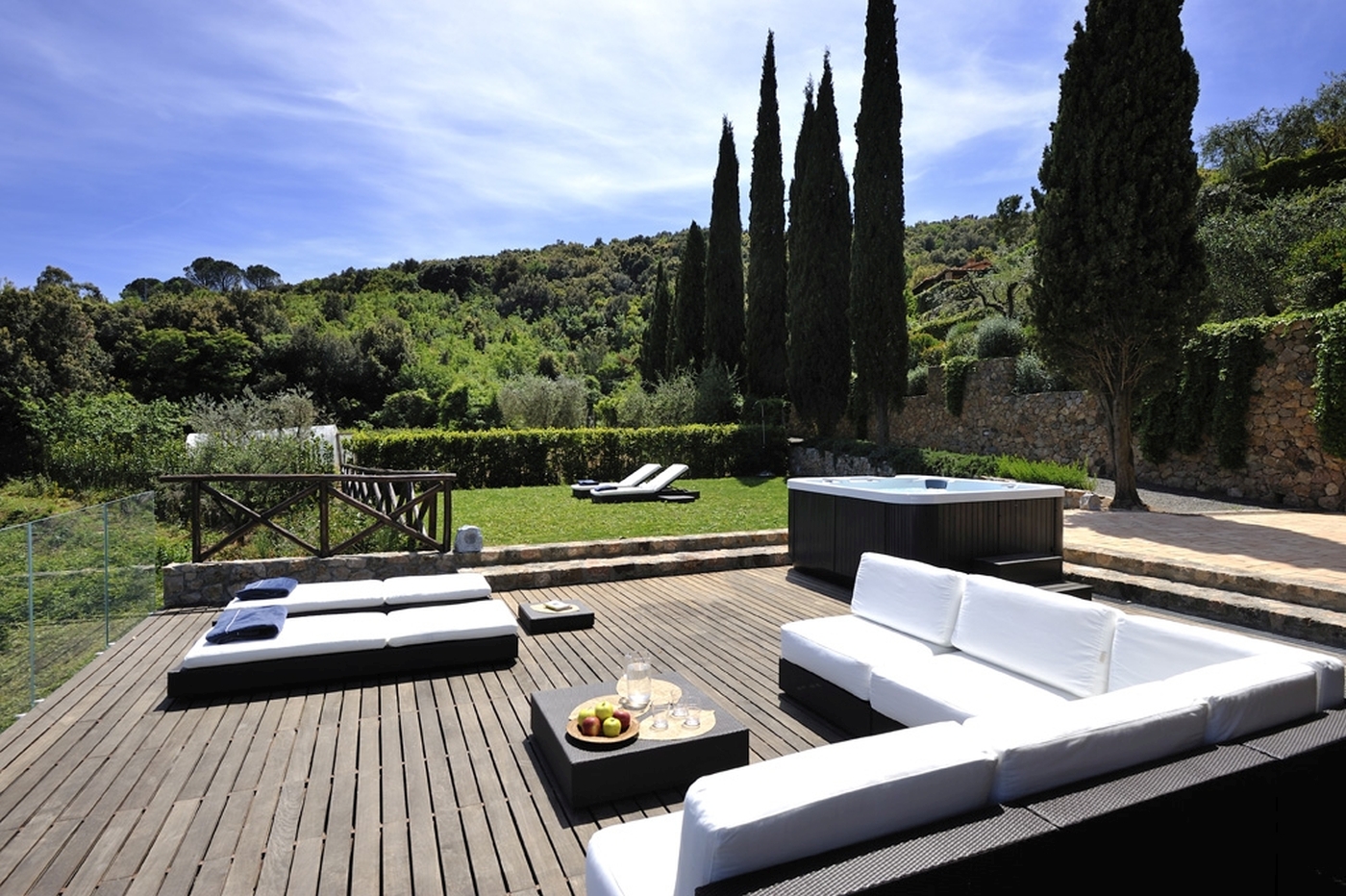 A large decked terrace with sun beds and cushioned seating