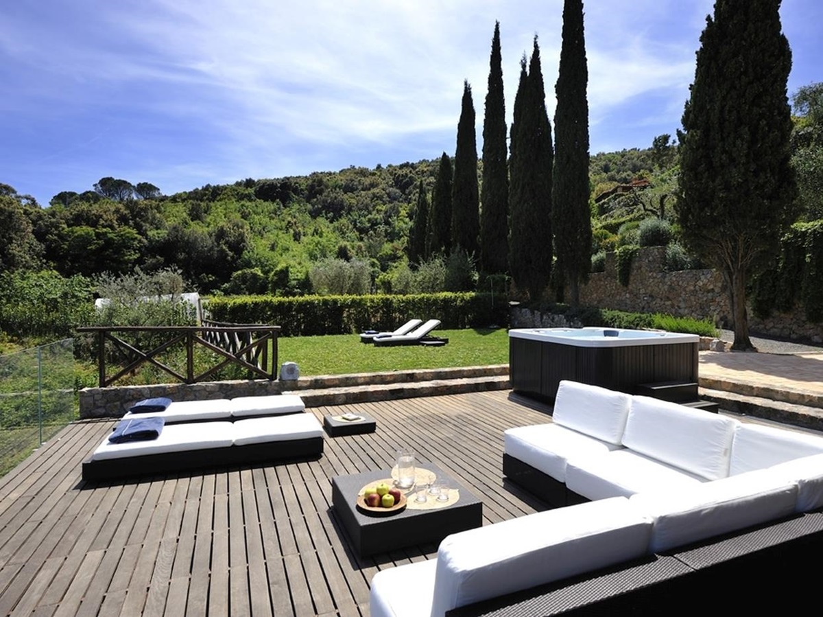 A large decked terrace with sun beds and cushioned seating
