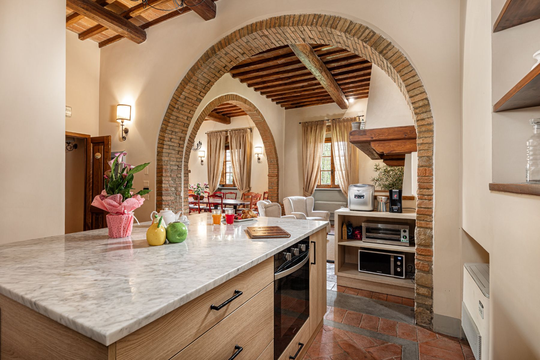 Kitchen area with a marble island and view of the indoor lounge area at Villa Il Sole in Tuscany