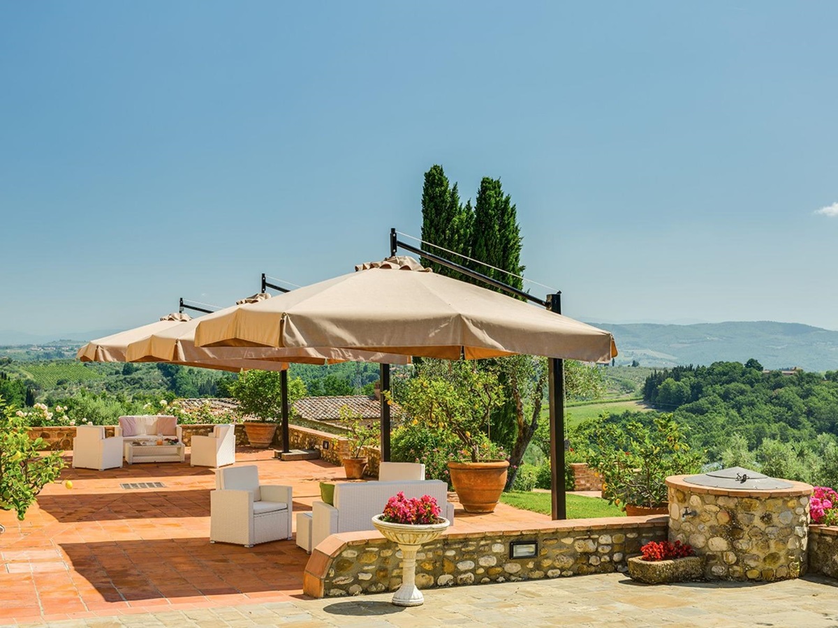 Outdoor lounge area under large umbrellas on the patio at Villa Il Sole in Tuscany