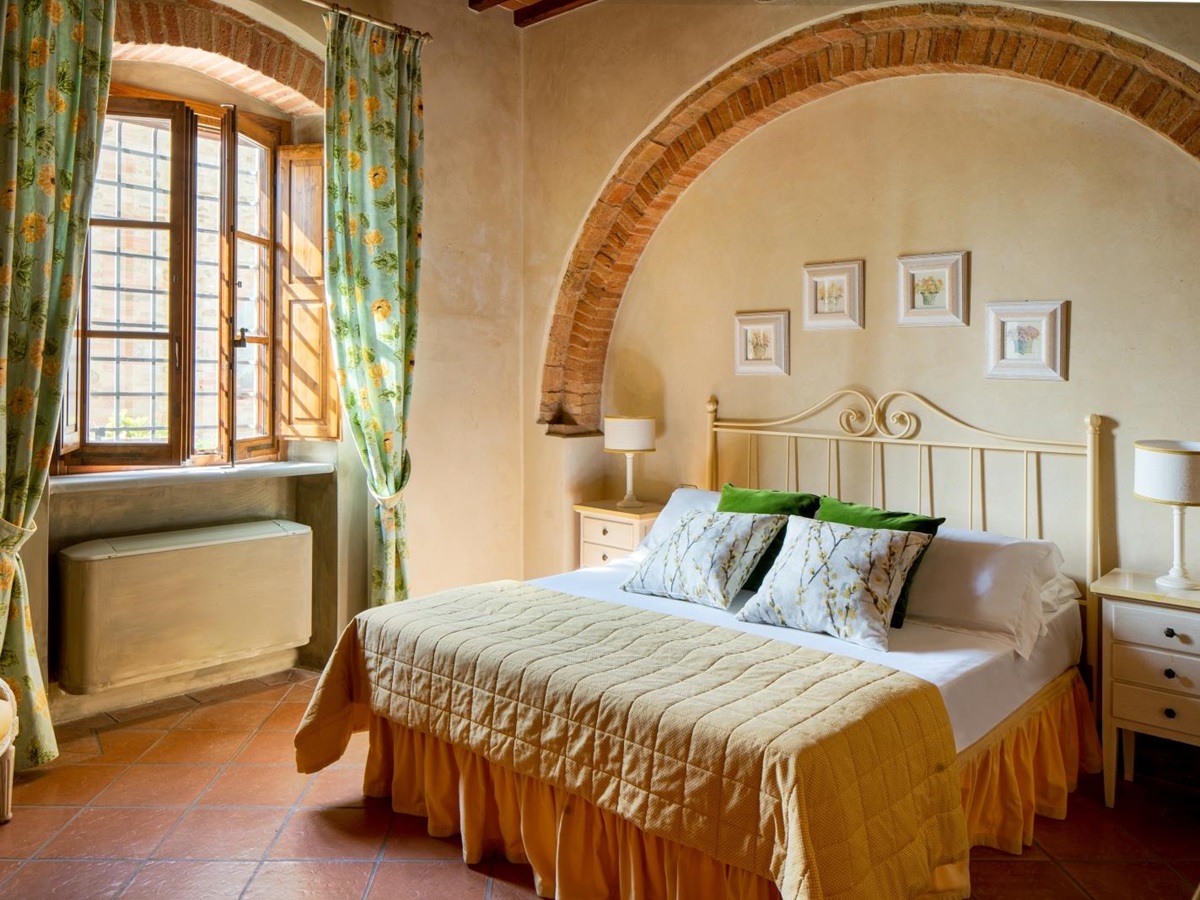Double bedroom with stone arch at Villa Il Sole in Tuscany