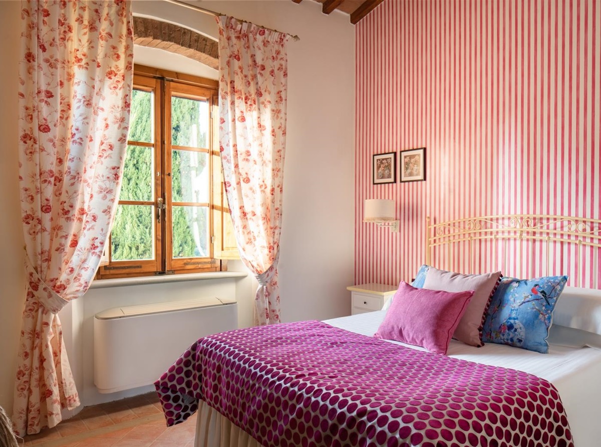 Double bedroom with pink wallpaper at Villa Il Sole in Tuscany