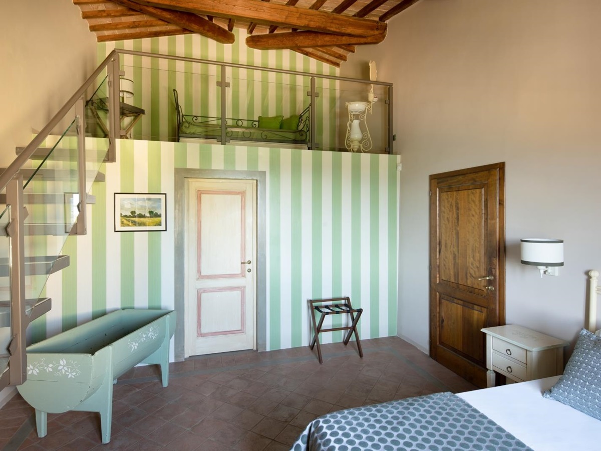Double bedroom with striped wallpaper at Villa Il Sole in Tuscany