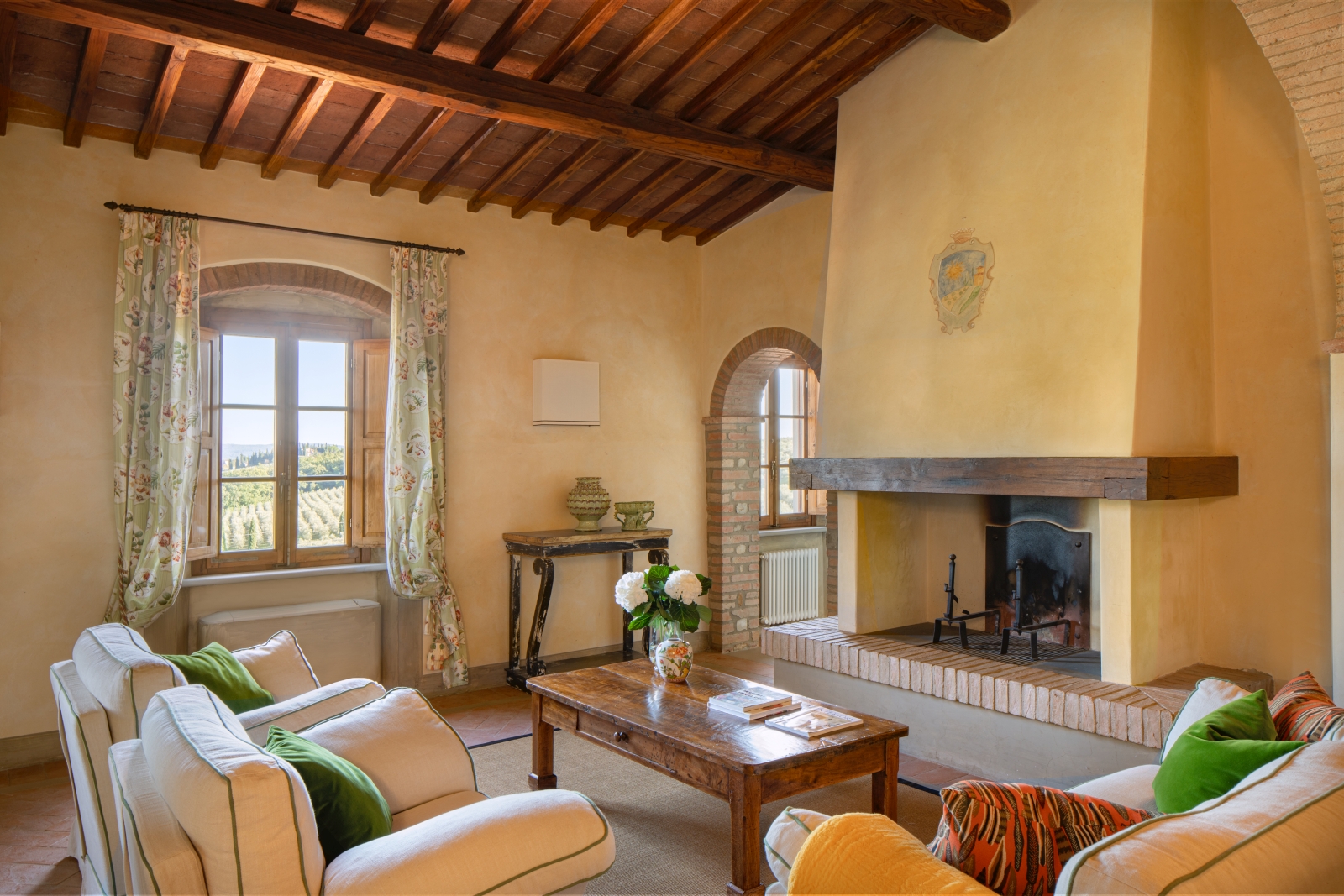 Living room with fireplace and coffee table at Villa Il Sole in Tuscany