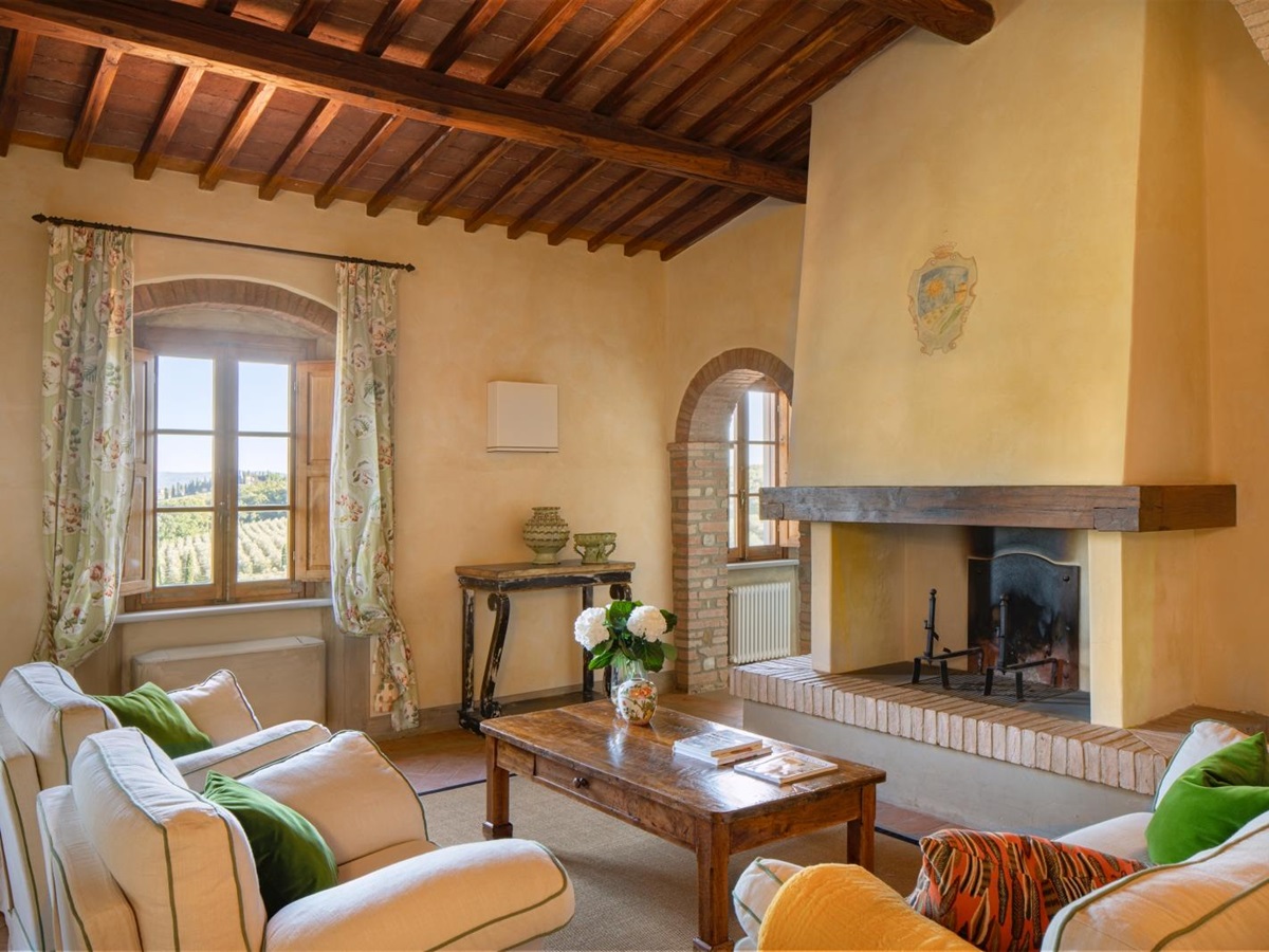 Living room with fireplace and coffee table at Villa Il Sole in Tuscany