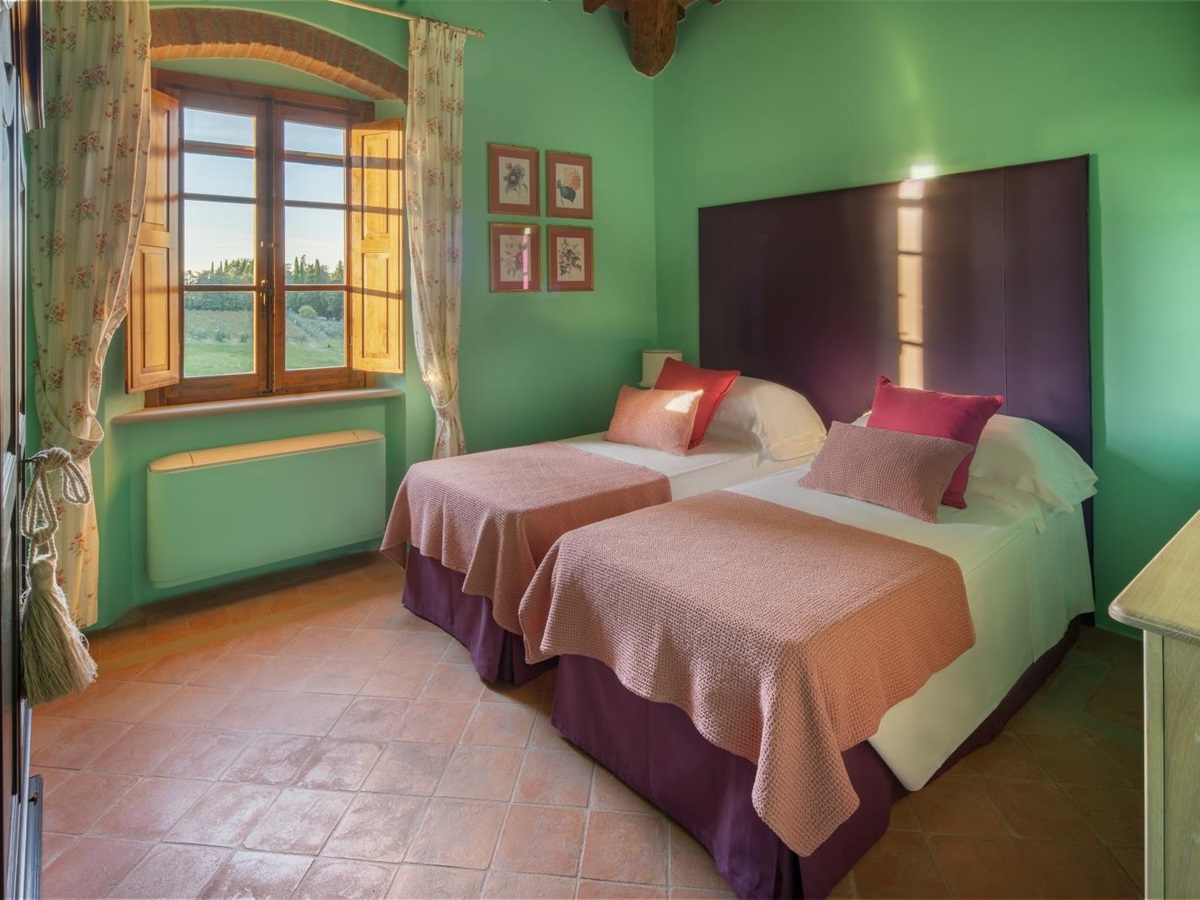 Twin bedroom with green walls at Villa Il Sole in Tuscany