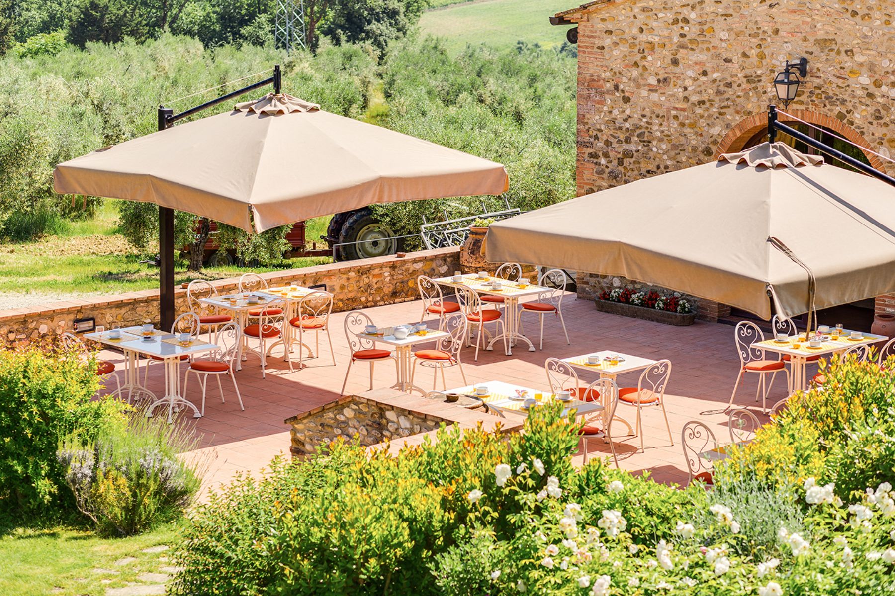 Outdoor seating area at Villa Il Sole in Tuscany under large umbrellas