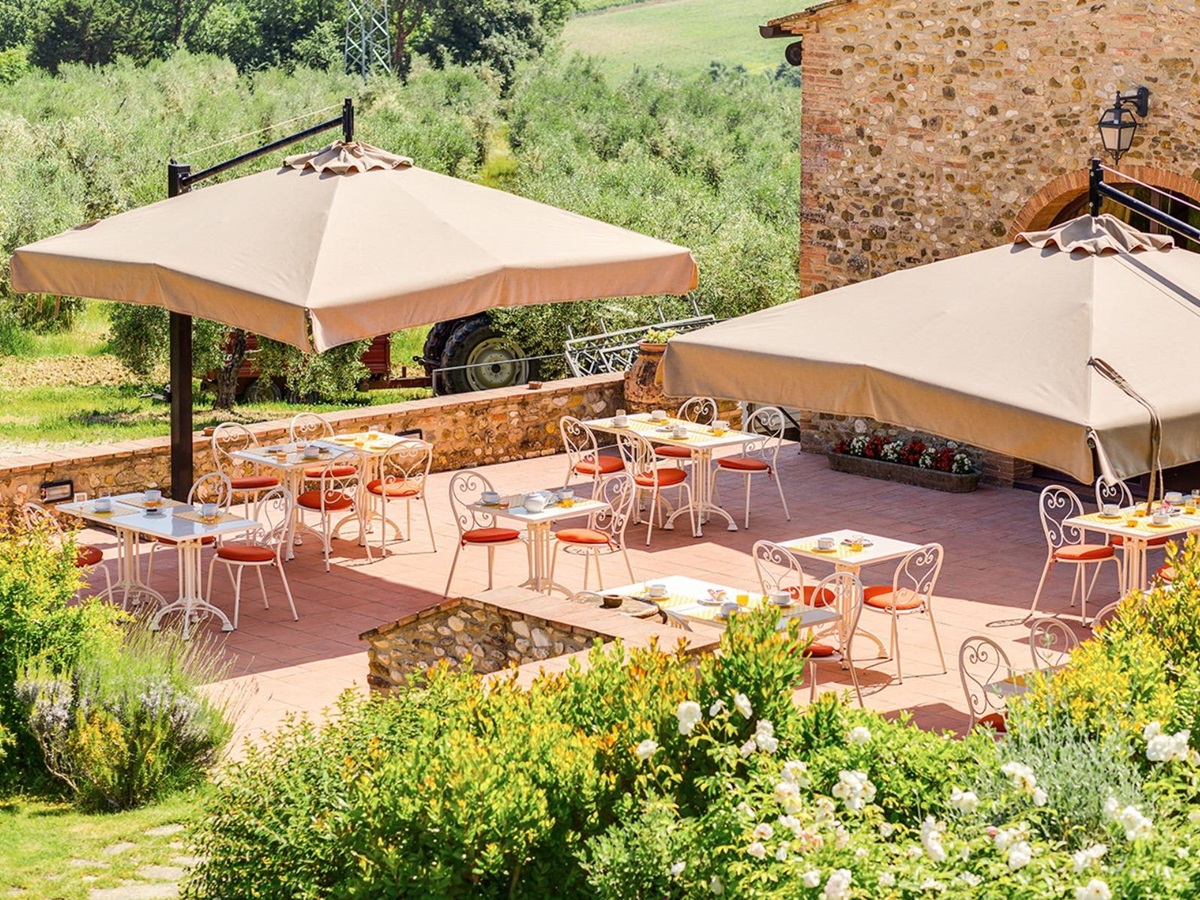 Outdoor seating area at Villa Il Sole in Tuscany under large umbrellas