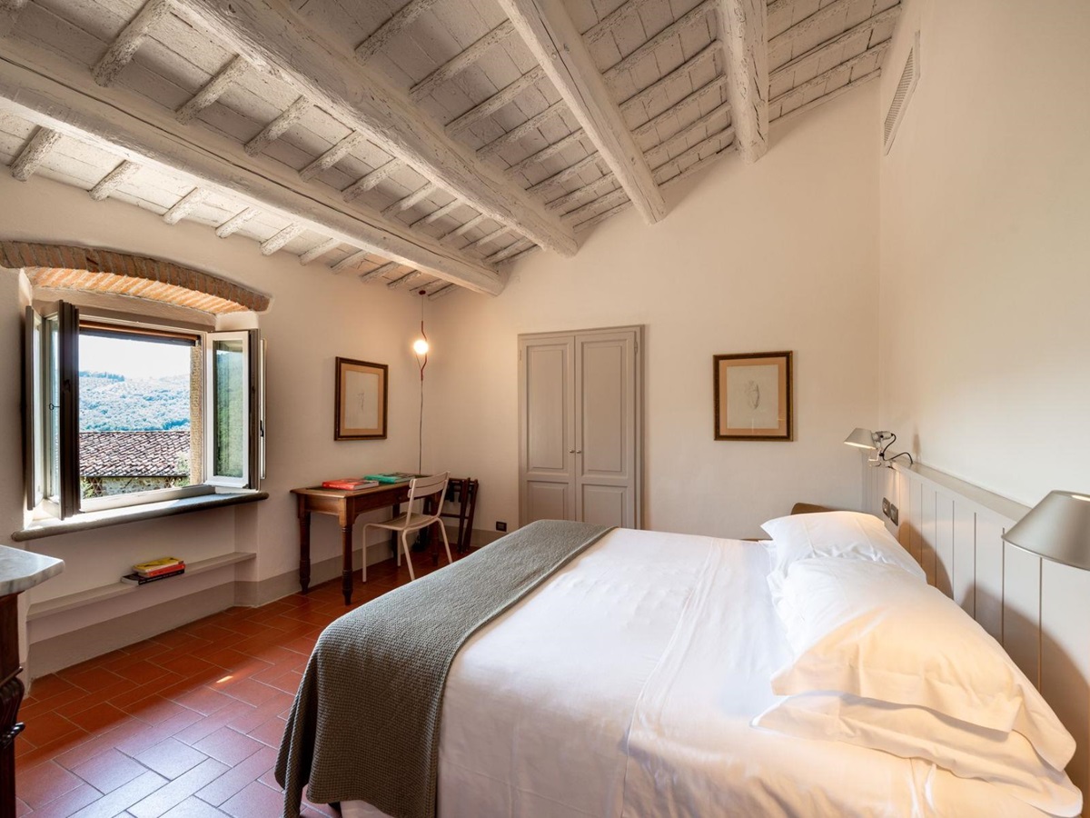 Double bedroom with wooden beam roof and modern decor at Villa Luce in Tuscany