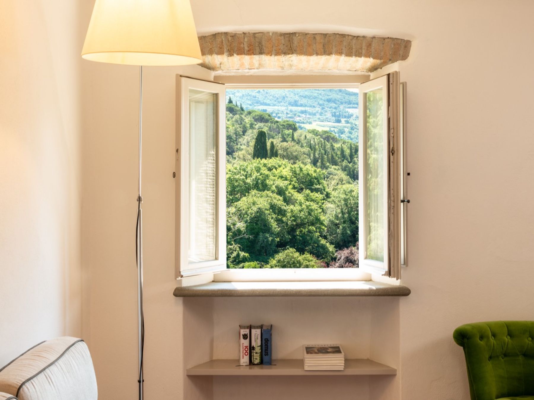 Large open window with view of trees at Villa Luce in Tuscany