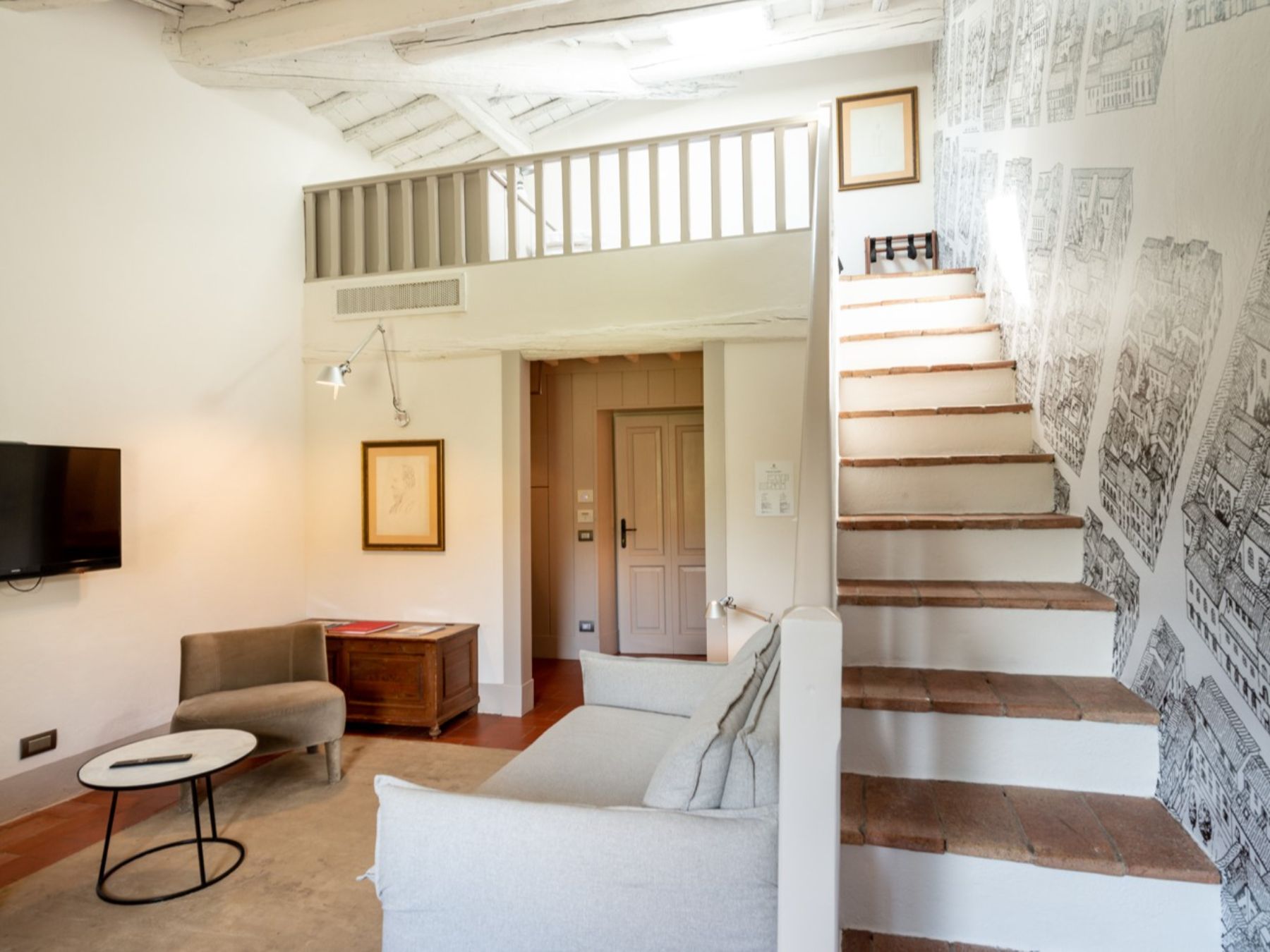 Small living room area with stairs leading up towards a bedroom at Villa Luce in Tuscany