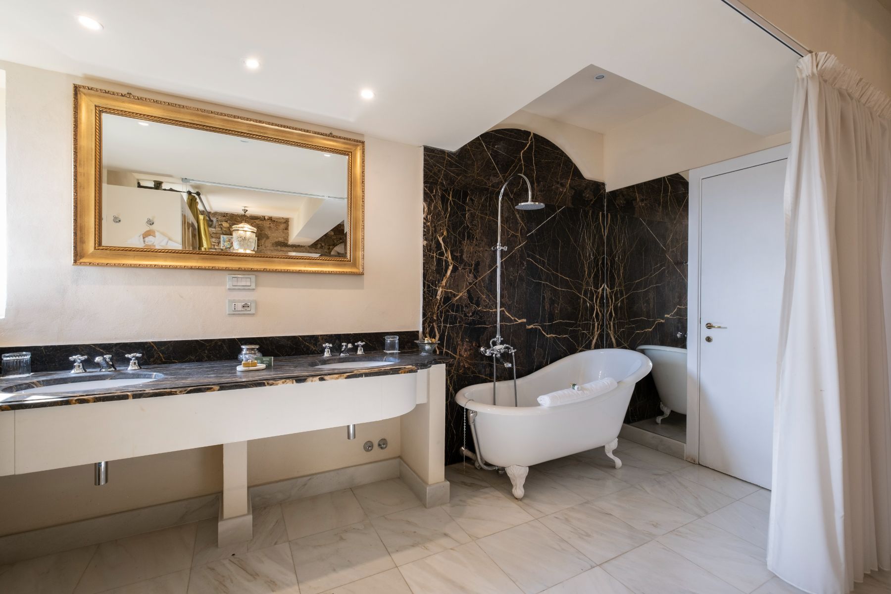 View of the bathroom with black marble featuring a bath and basin at Villa Machiavelli in Tuscany