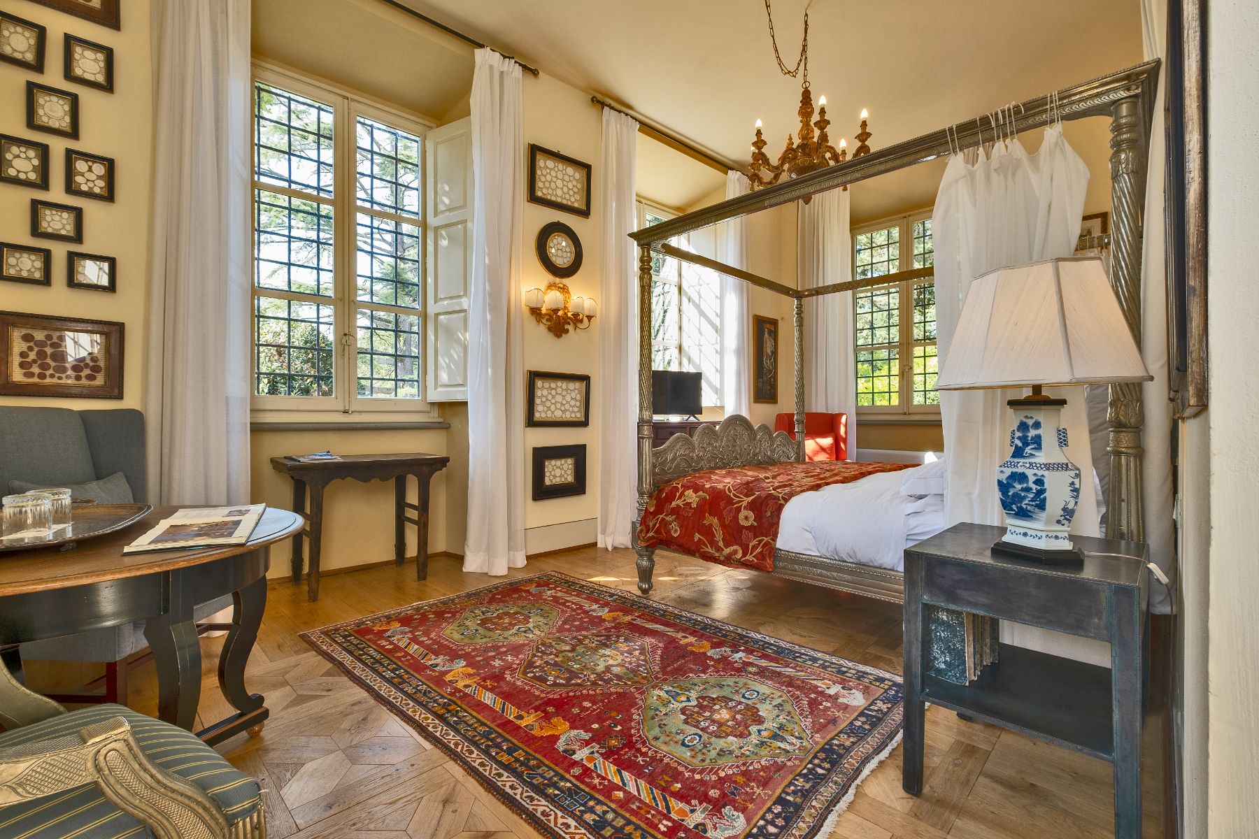 Bedroom with large windows and colourful rug at Villa Machiavelli in Tuscany