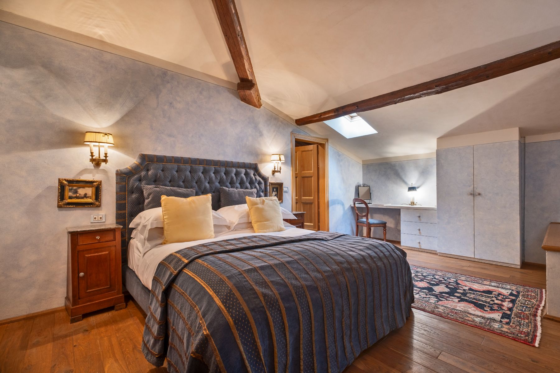 bedroom with a large double bed and blue bedsheets and wall paper at Villa Machiavelli in Tuscany