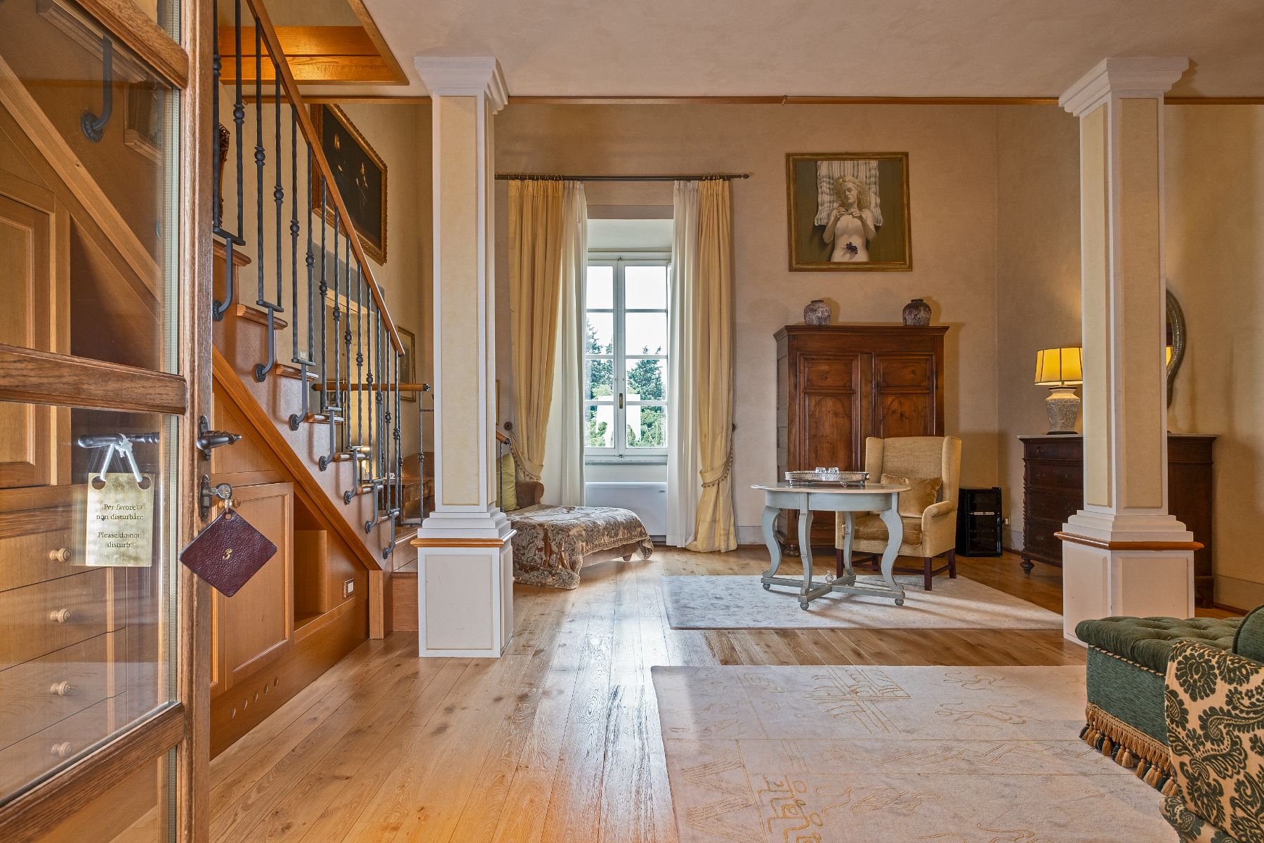 Entrance room with artwork and wooden floors at Villa Machiavelli in Tuscany