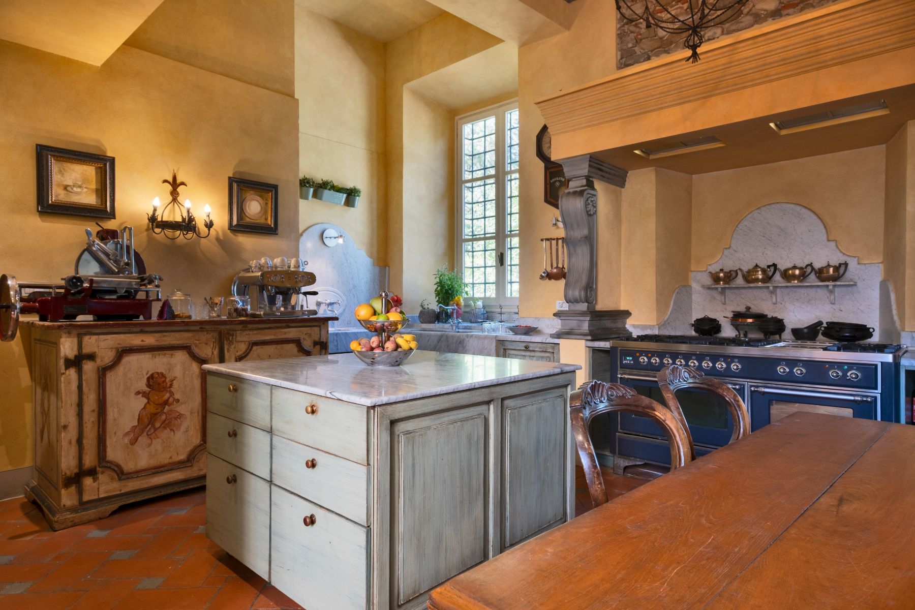 Kitchen with blue oven and yellow wallpaper at Villa Machiavelli in Tuscany
