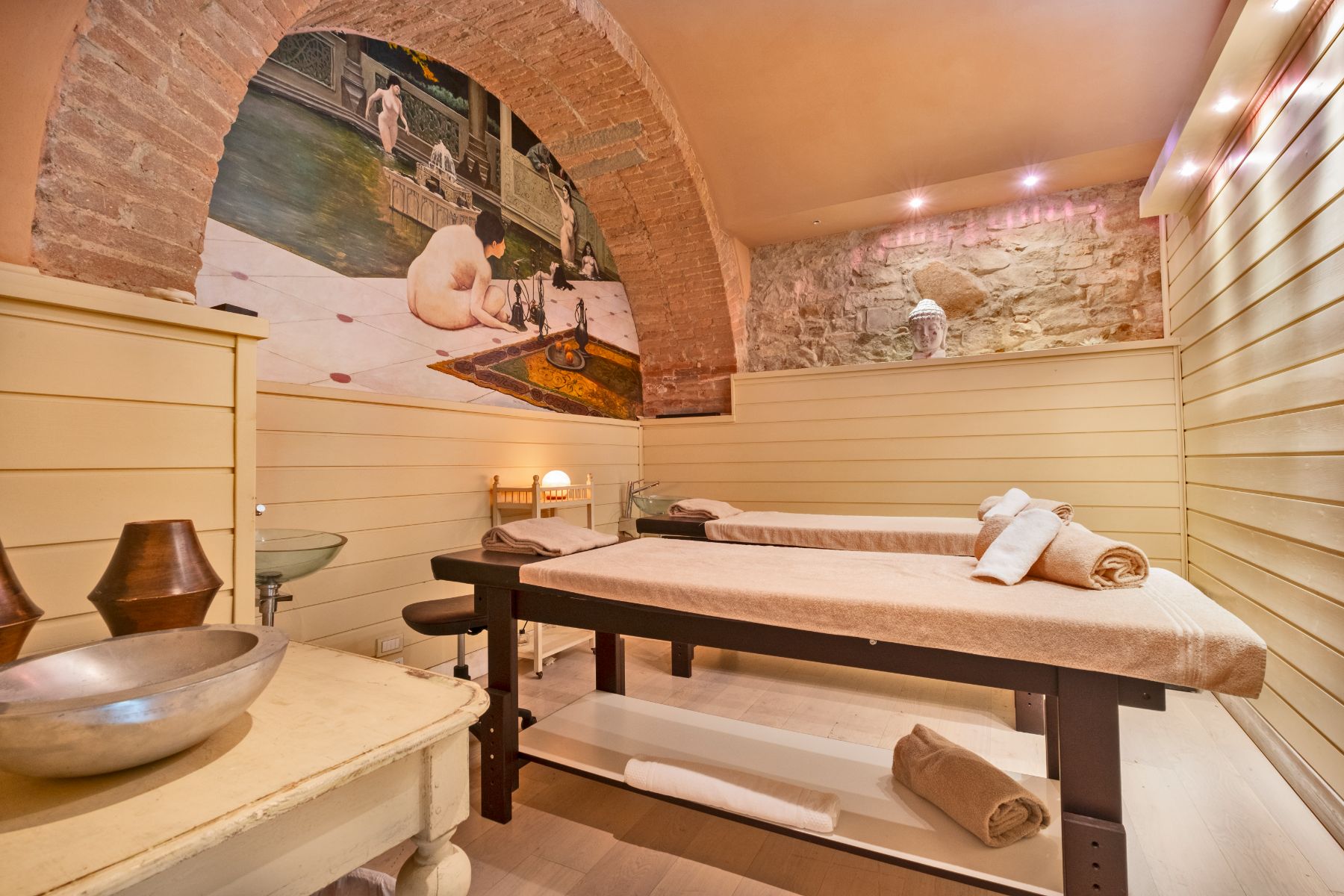 Massage room with two massage beds and artwork on the wall at Villa Machiavelli in Tuscany