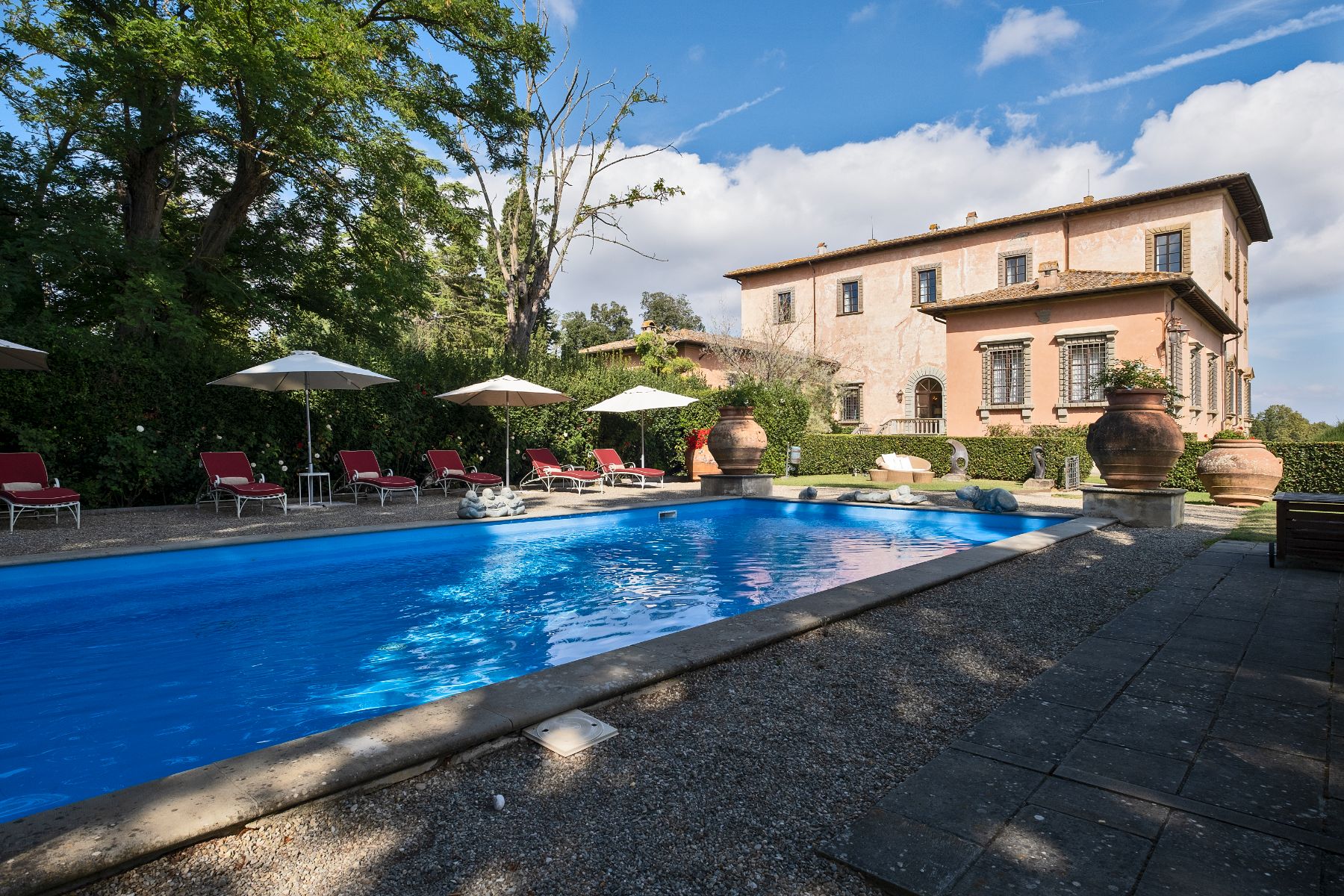 Outdoor pool at Villa Machiavelli with view of the property and the sun lounging area