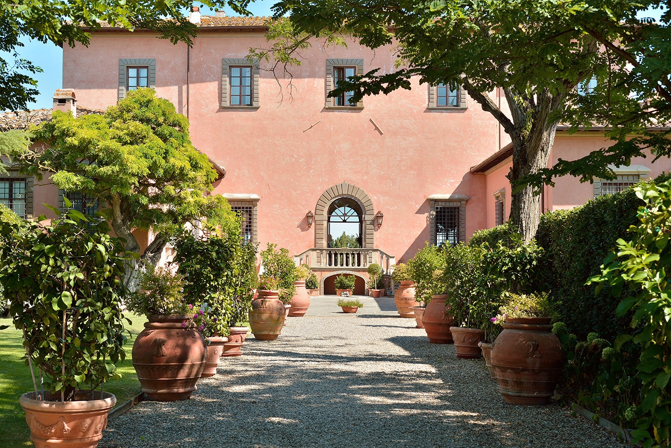 Entrance walkway to villa with plants and trees at Villa Machiavelli in Tuscany, Italy