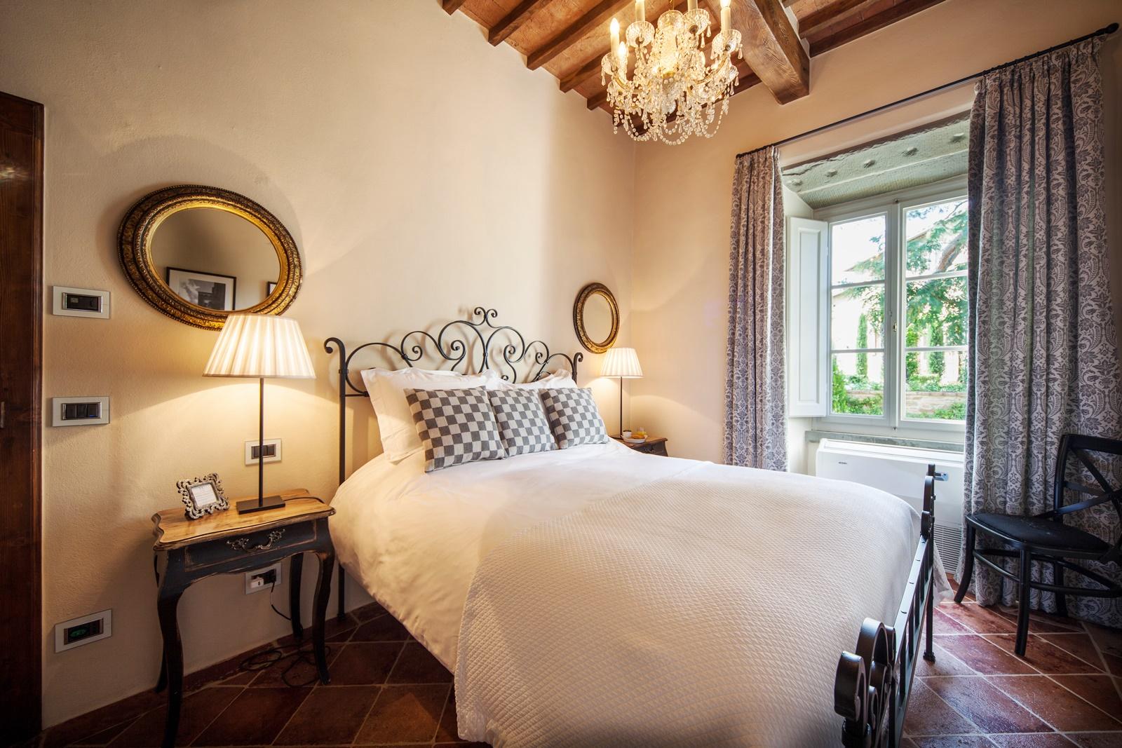 Double bedroom with chandelier in Villa Nocciola, Tuscany