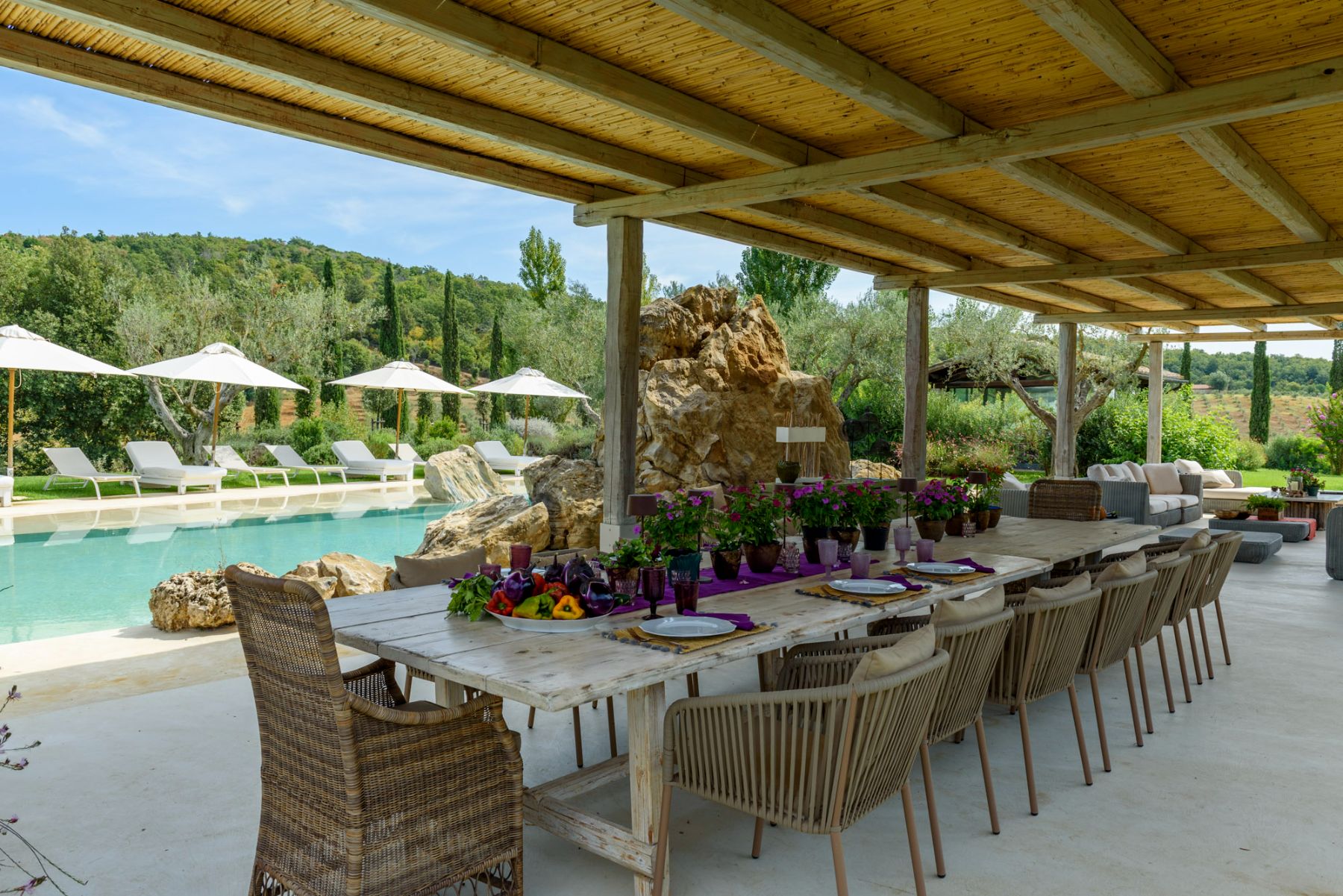 Outdoor dining table and pool at Villa Pacetezza in Tuscany
