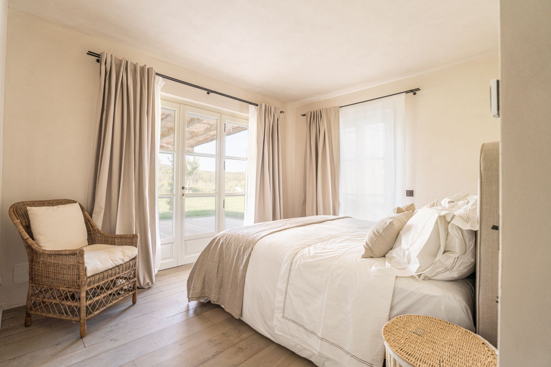 Bedroom with a brown chair in corner in Villa Pedemontana in Tuscany
