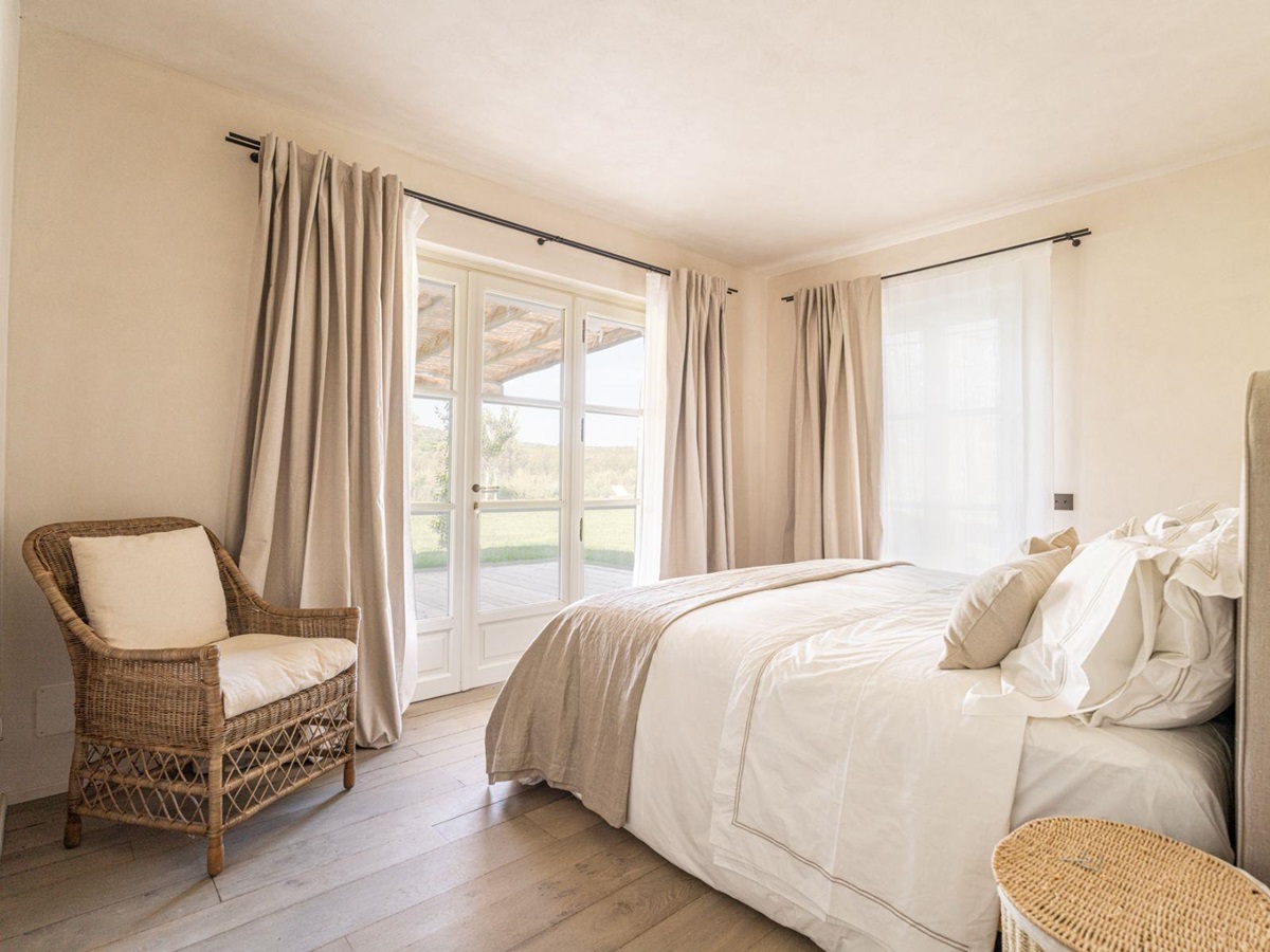 Bedroom with a brown chair in corner in Villa Pedemontana in Tuscany