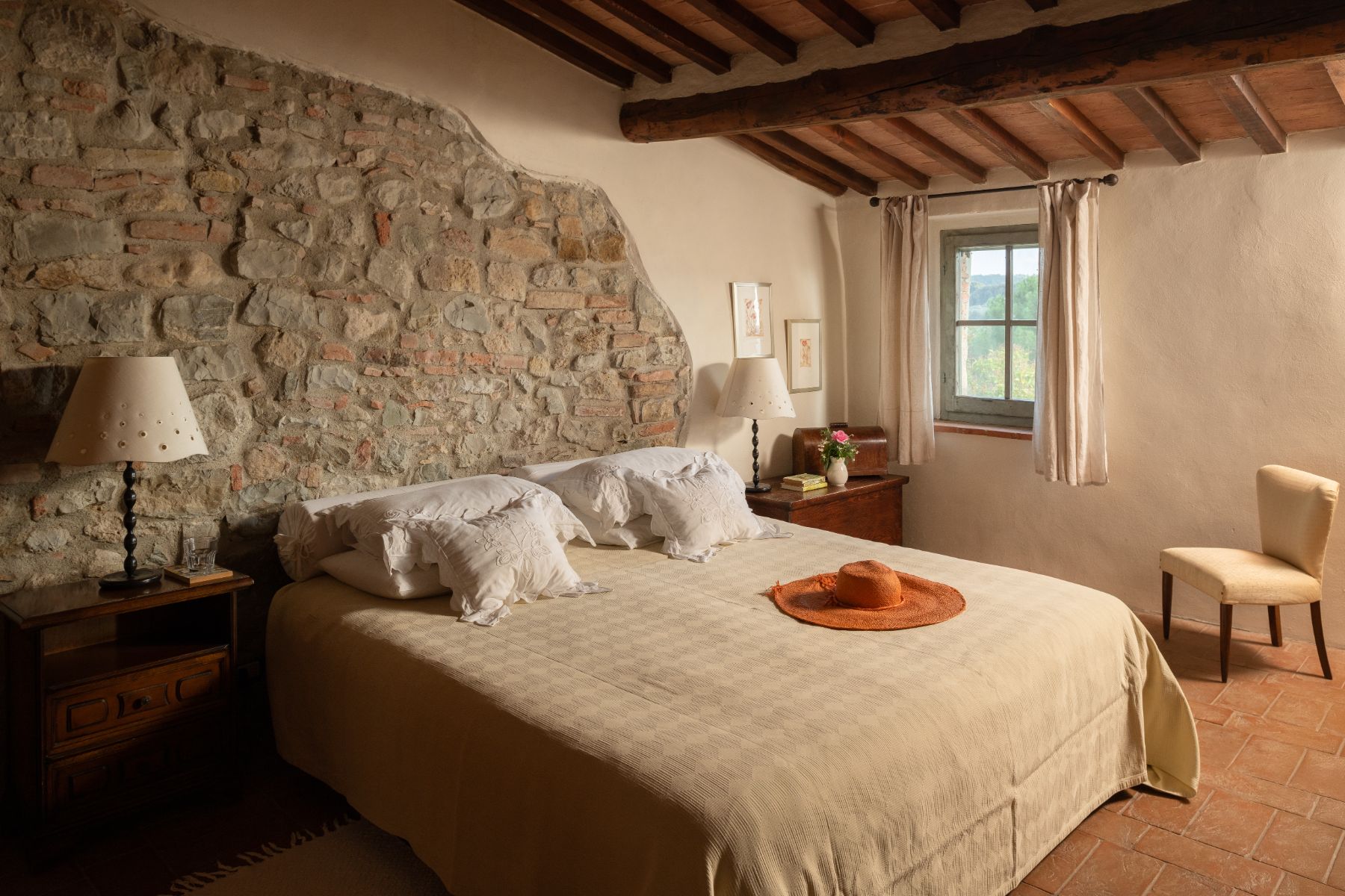 Bedroom with large double bed and traditional brick walls at Villa San Barberino in Tuscany