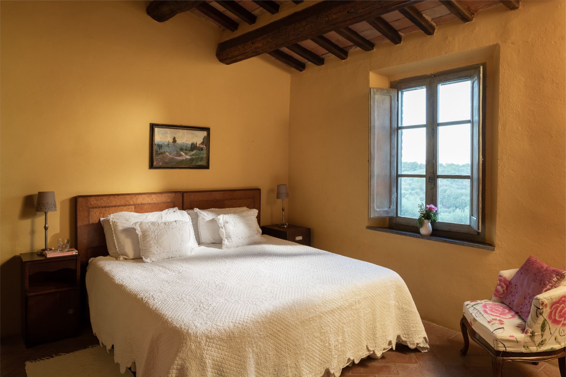 Bedroom with a large double bed and yellow wall paper at Villa San Barberino in Tuscany