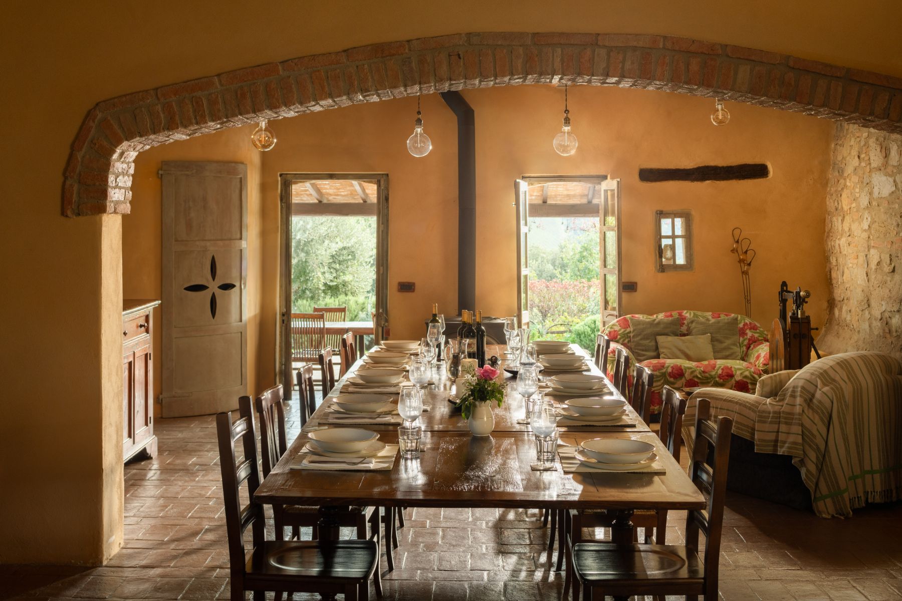 Indoor dining table with wooden chairs and sofas at Villa San Barberino in Tuscany