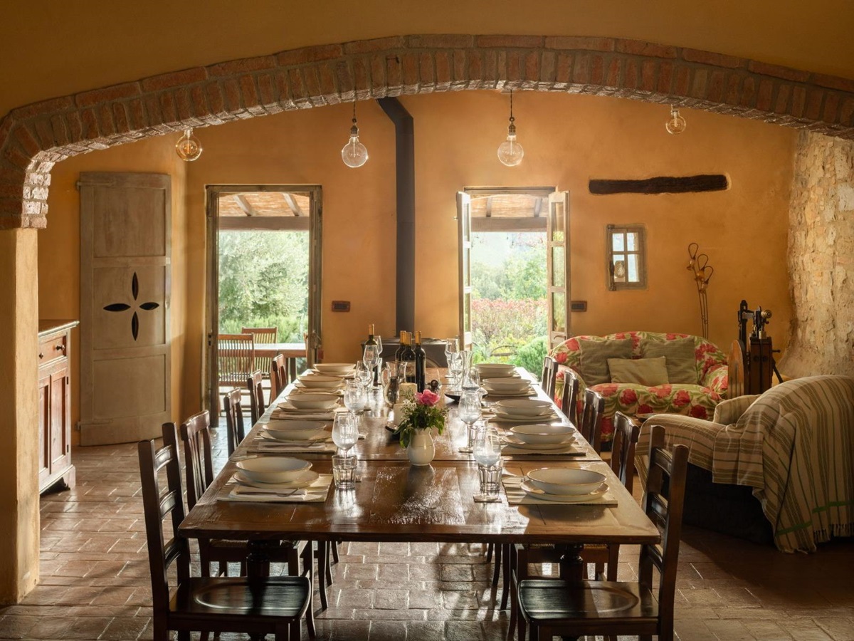 Indoor dining table with wooden chairs and sofas at Villa San Barberino in Tuscany