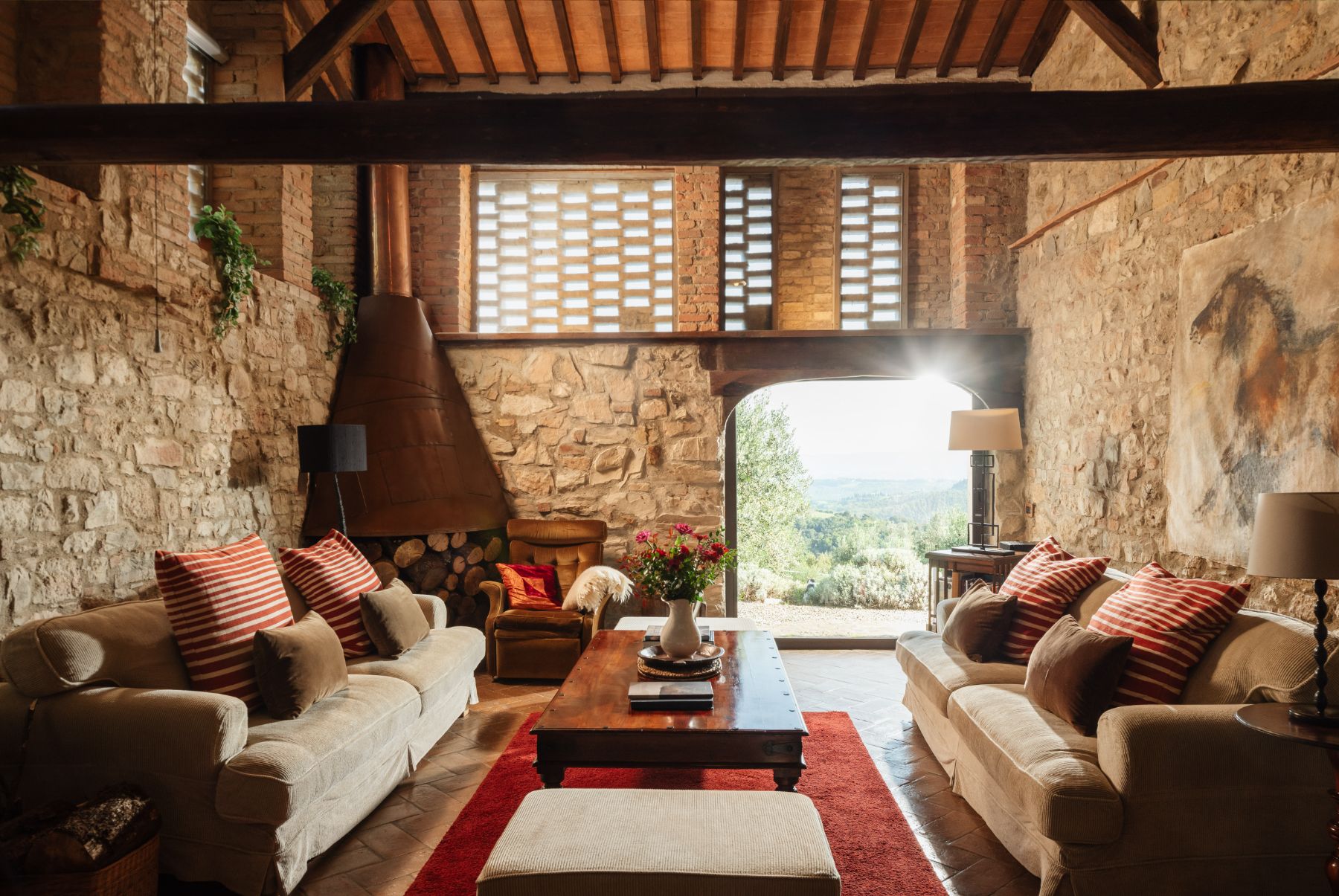 Indoor lounge room with sofas and brick walls at Villa San Barberino in Tuscany