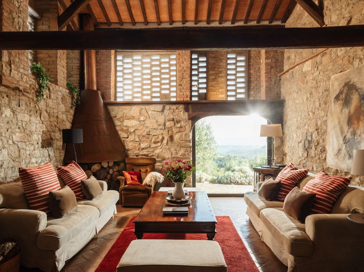 Indoor lounge room with sofas and brick walls at Villa San Barberino in Tuscany