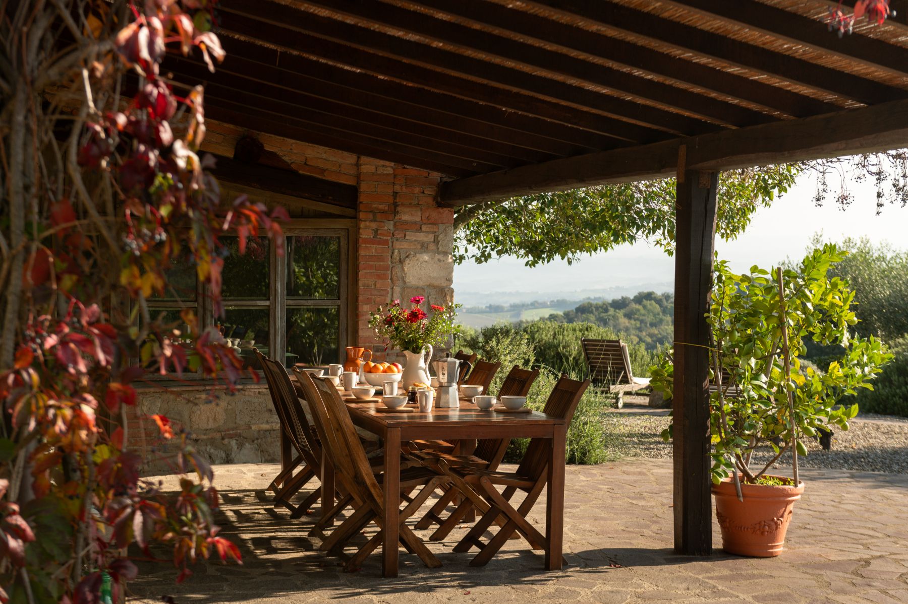 Outdoor dining table with wooden chairs at Villa San Barberino in Tuscany