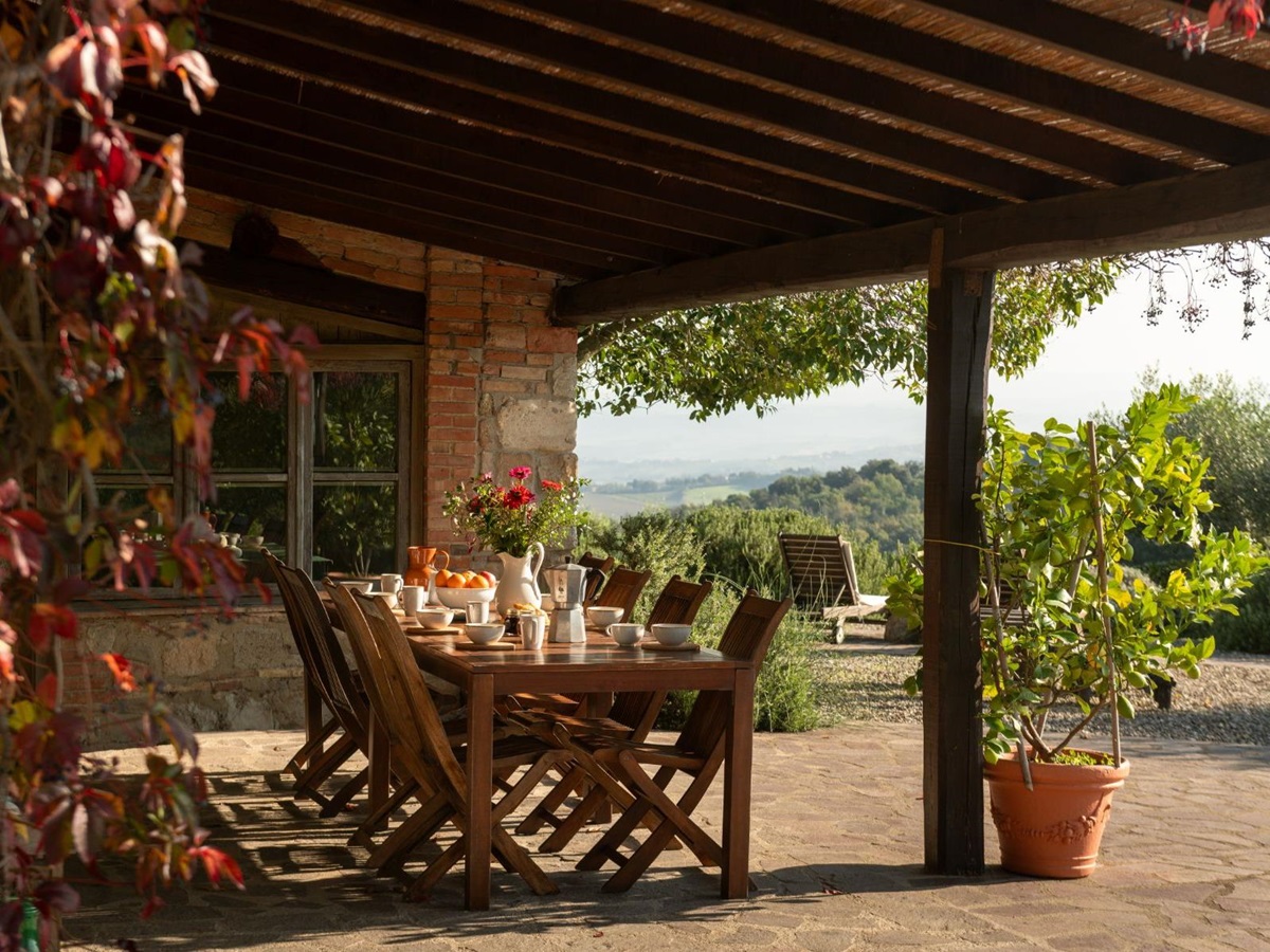 Outdoor dining table with wooden chairs at Villa San Barberino in Tuscany